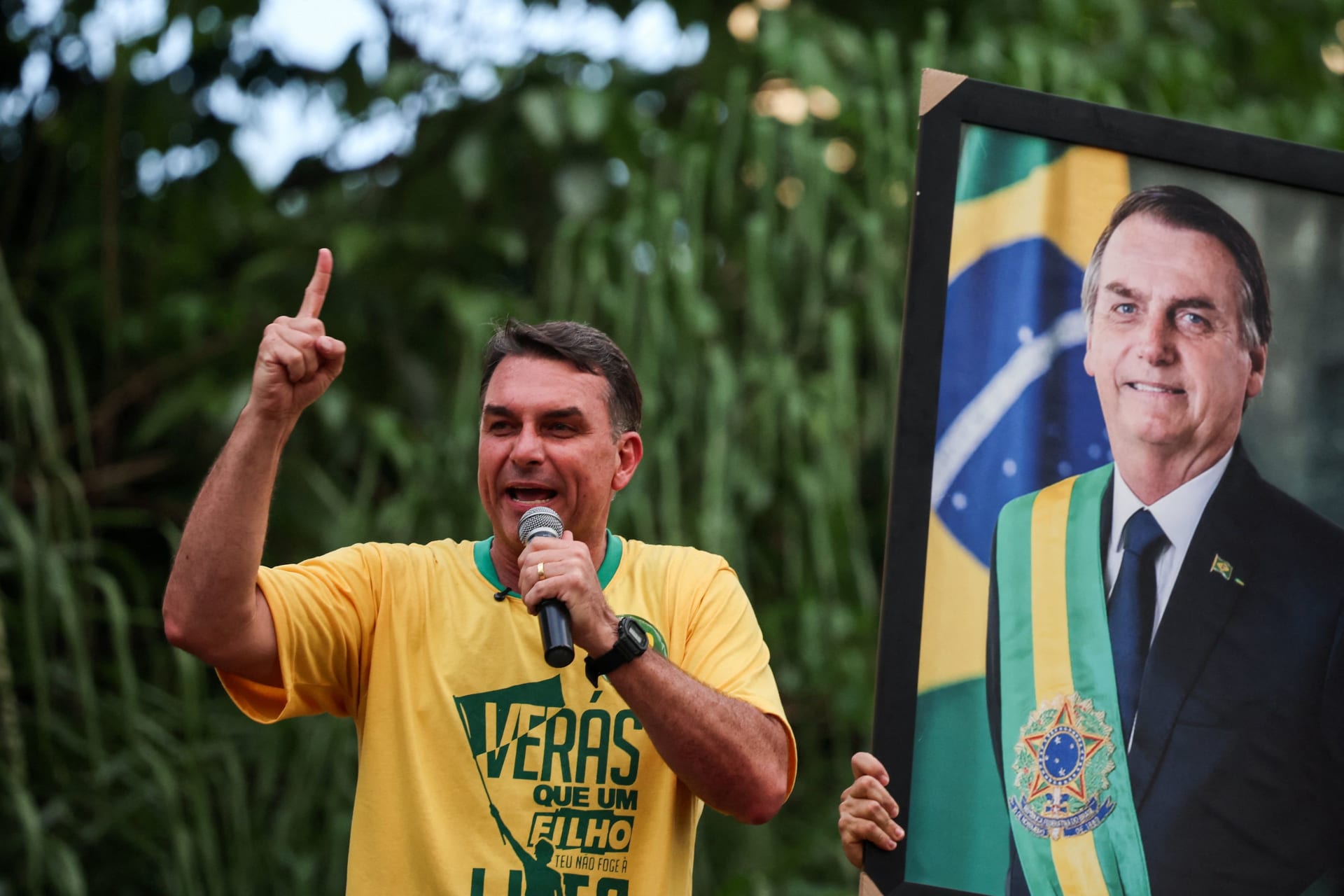 Brazilian presidential candidate Flavio Bolsonaro of the Liberal Party (PL) speaks next to a portrait of his father, Brazil's former President Jair Bolsonaro, during a campaign rally in Goiania, Brazil, September 27, 2026.