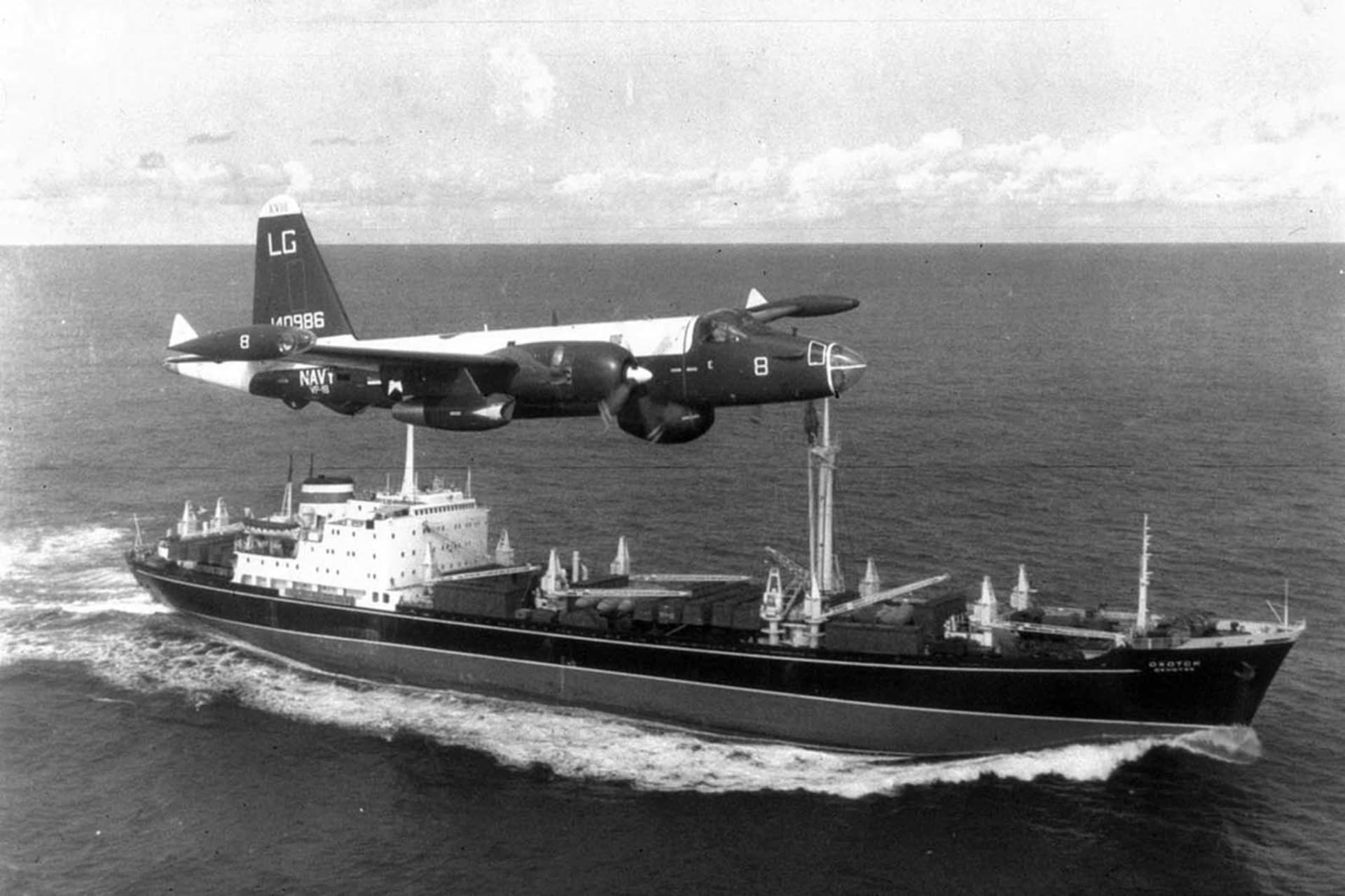 <p>A U.S. Navy P2V Neptune patrol plane flies over a Soviet freighter <i>Okhotsk,</i> loaded with aircraft parts and bombs, leaving Cuba, December 5, 1962.</p>
