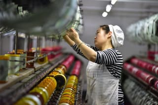 <p> A silk textile worker stands on the production line of a factory in Fuyang, China.</p>