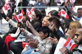 <p>New Canadians wave the national flag during a citizenship ceremony in Toronto.</p>