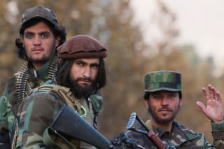 Members of Taliban sit on a military vehicle during Taliban military parade in Kabul