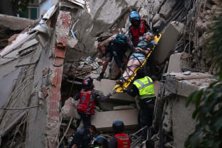 Rescue workers carry a person on a stretcher out of a collapsed building following an earthquake in Caracas on June 24, 2026.
