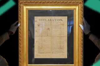Handlers hold a July 1776 printing of the Declaration of Independence during a press preview at Sotheby's in New York City on January 17, 2025.