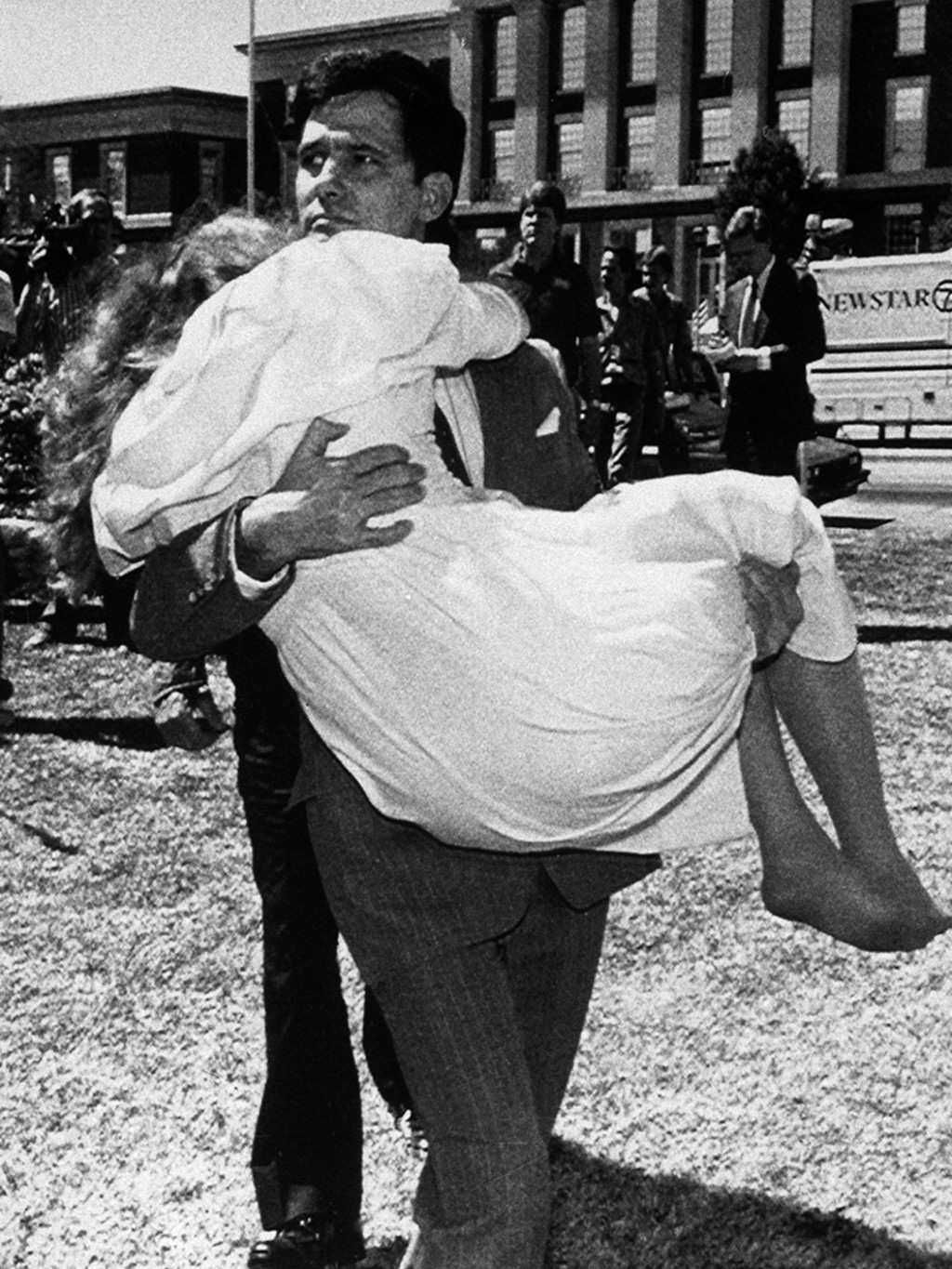 Louis Ray Beam Jr. carries his wife, Sheila, who had fainted, away from the federal courthouse in Fort Smith, Arkansas, after he and twelve other white supremacists are acquitted on sedition charges. 
