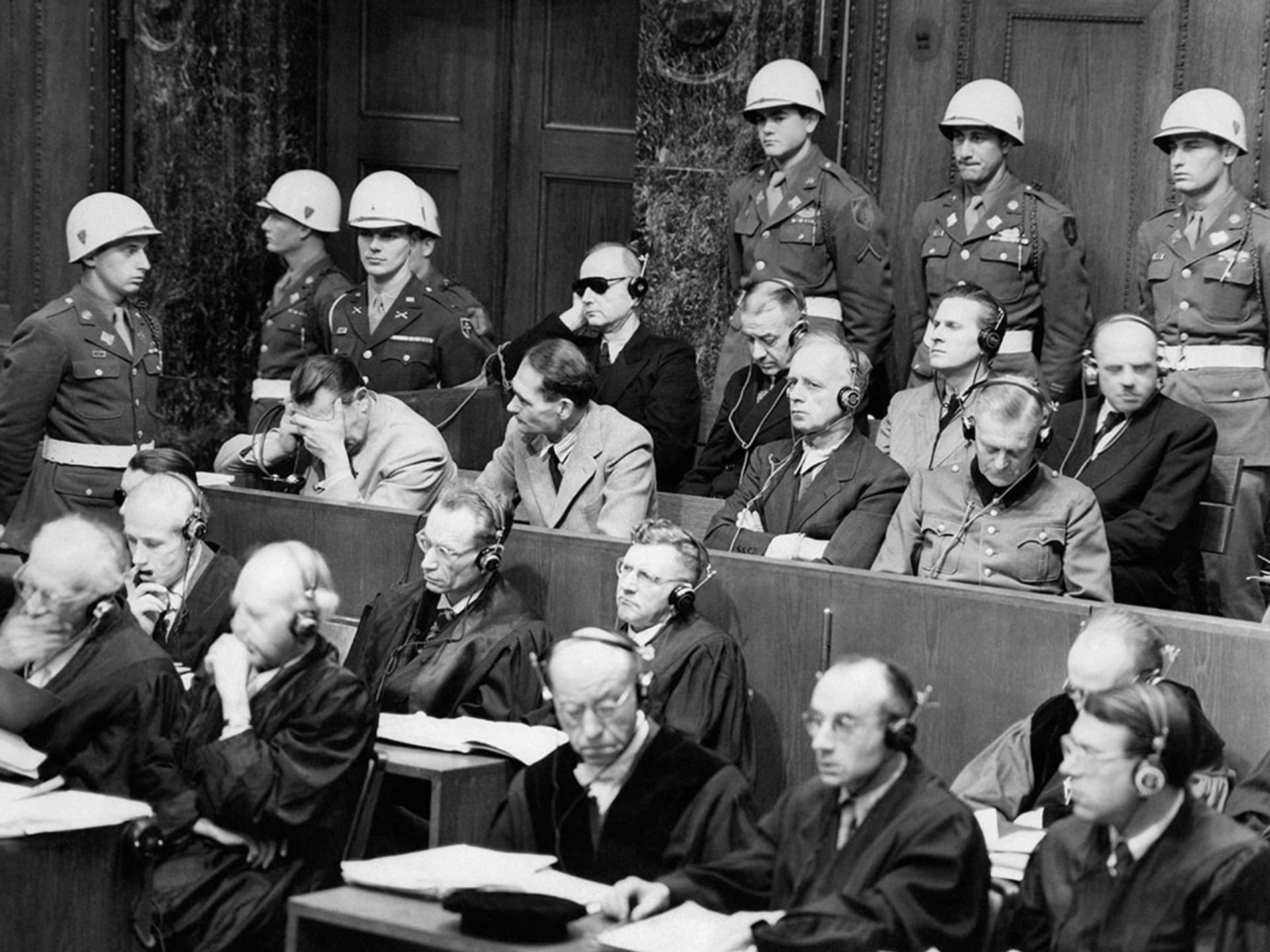High-ranking Nazi defendants sit in the dock of the courtroom at the Nuremberg war crimes trials. 
