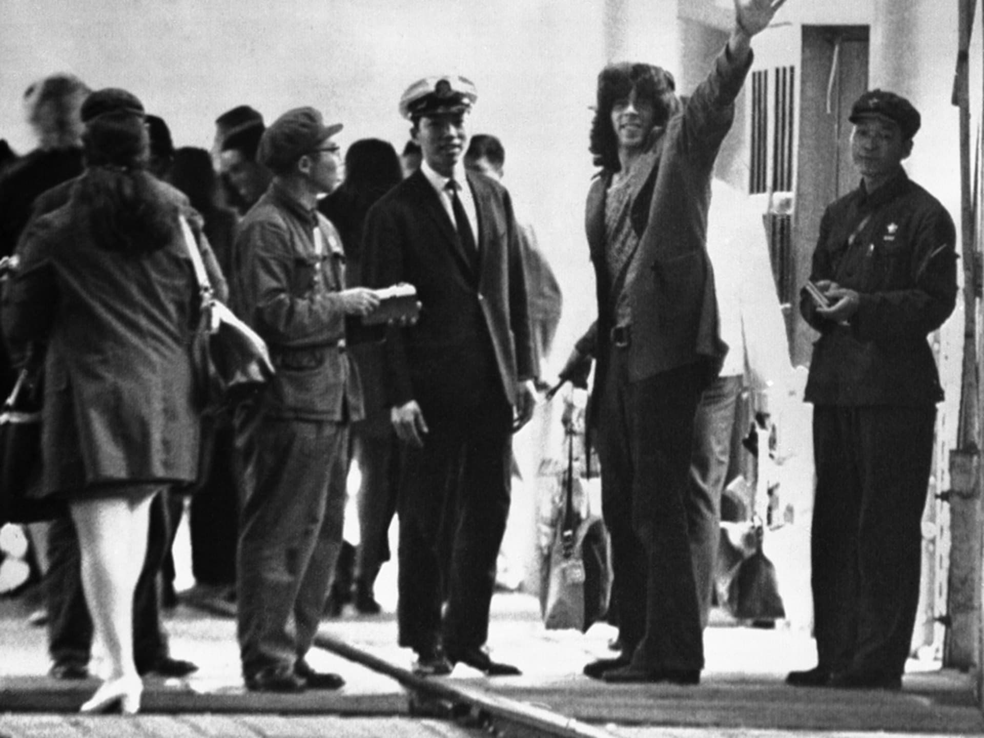 Glenn Cowan, a member of the U.S. ping-pong team, waves to reporters after entering mainland China.
