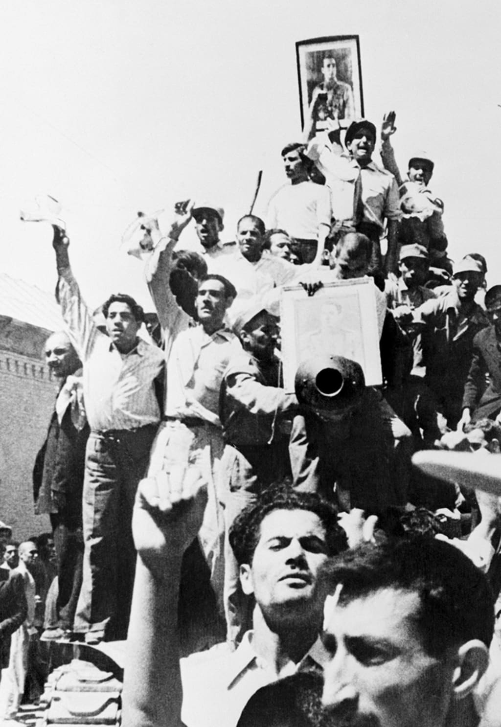 Iranians carry a portrait of the shah through the streets of Tehran after the overthrow of Prime Minister Mohammed Mossadeq. 

