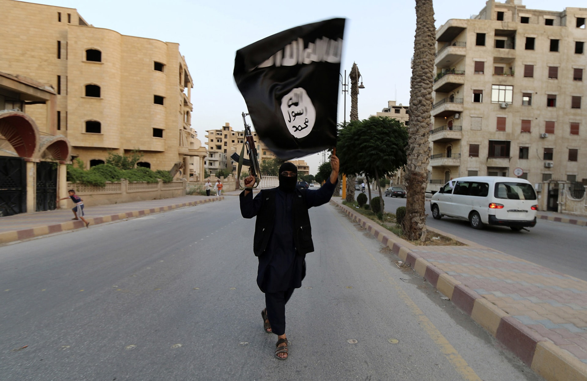 A member loyal to the Islamic State waves an Islamic State flag in Raqqa on June 29, 2014.