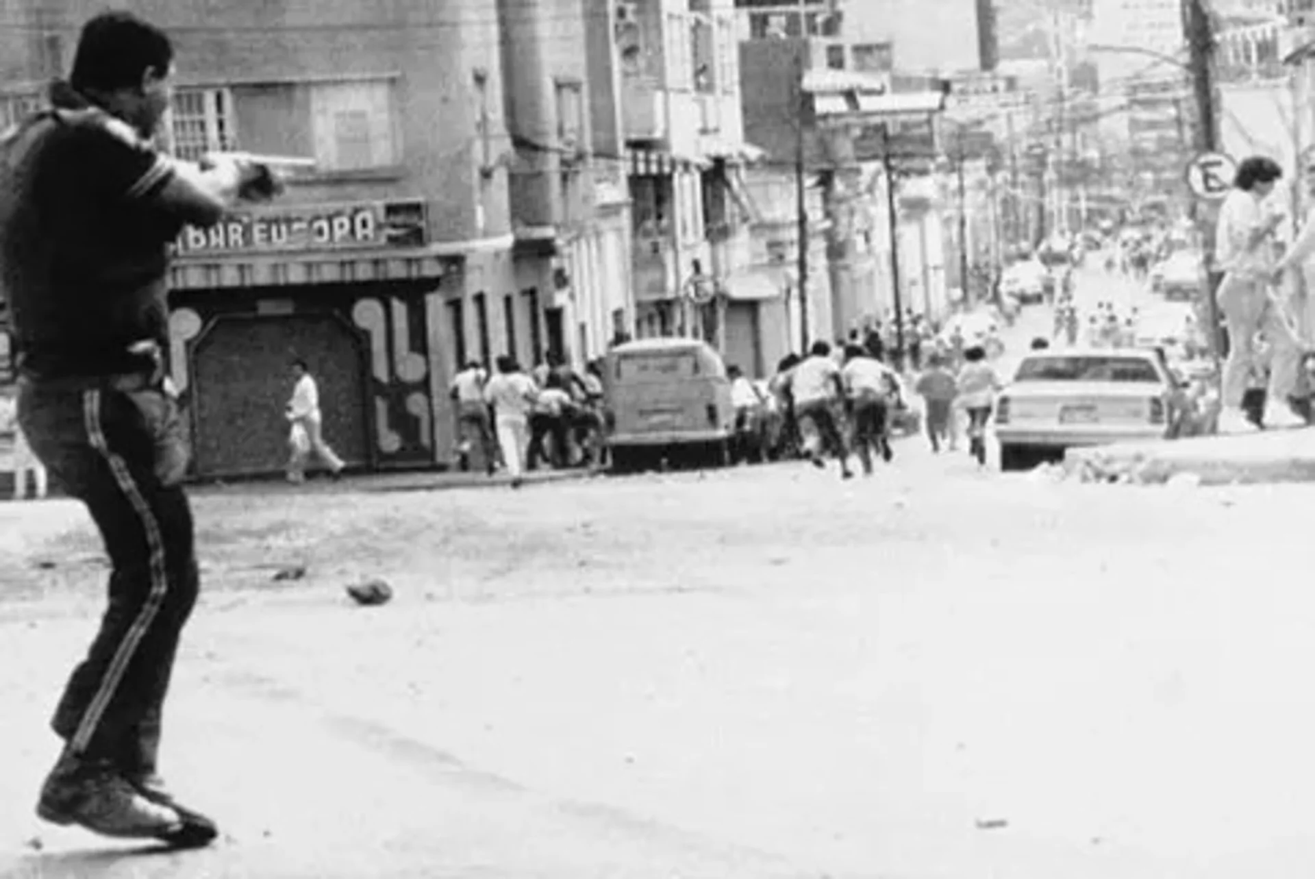 A metropolitan policeman shoots at a crowd in a Caracas neighborhood. 
