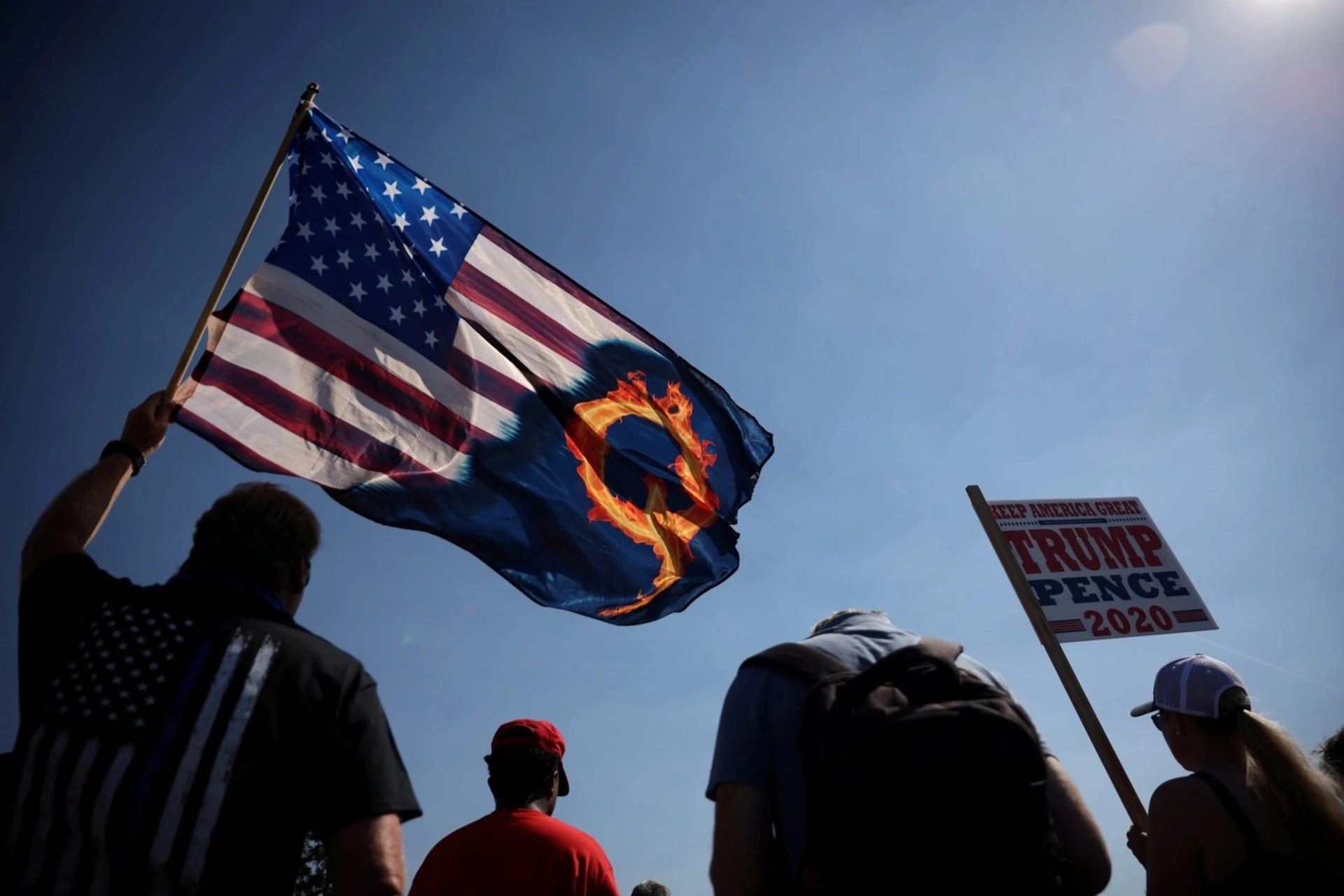 A supporter of President Donald Trump holds an U.S. flag with a reference to QAnon during a Trump 2020 Labor Day cruise rally. 
