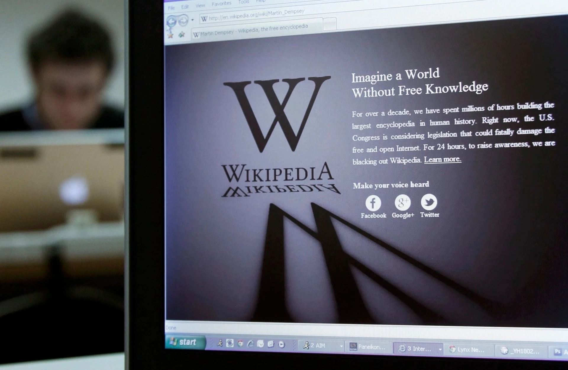 A reporter's laptop shows the Wikipedia blacked out opening page. 