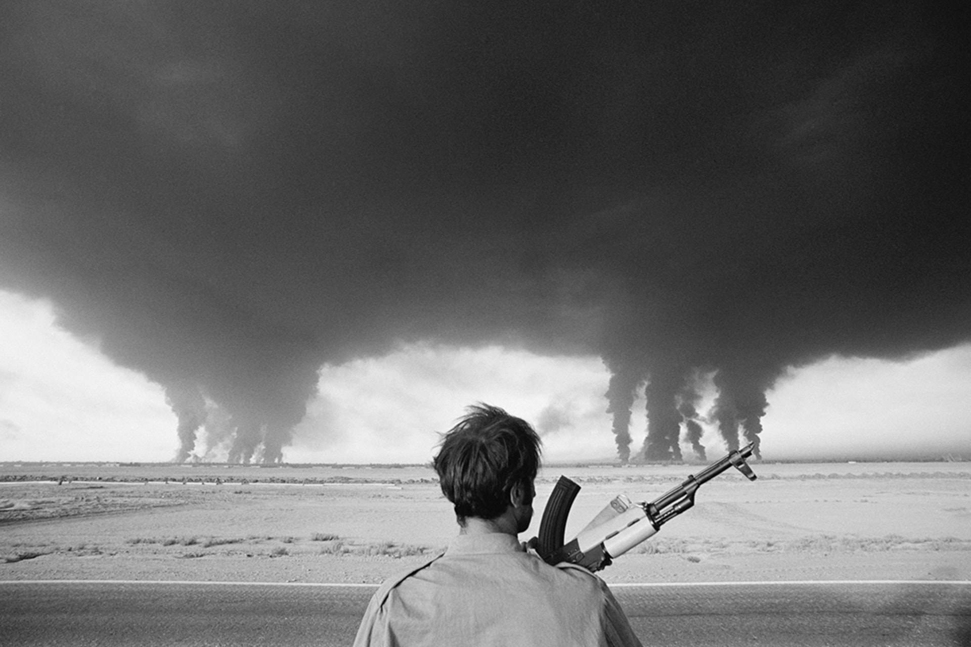 An Iraqi soldier watches the Iranian Abadan refinery burn during the Iran-Iraq conflict. 