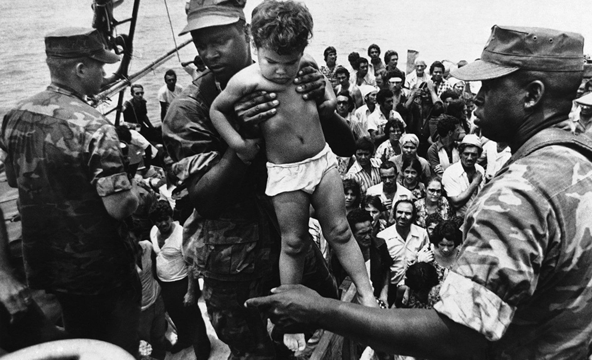 A U.S. Marine helps a child off of a Cuban refugee boat.