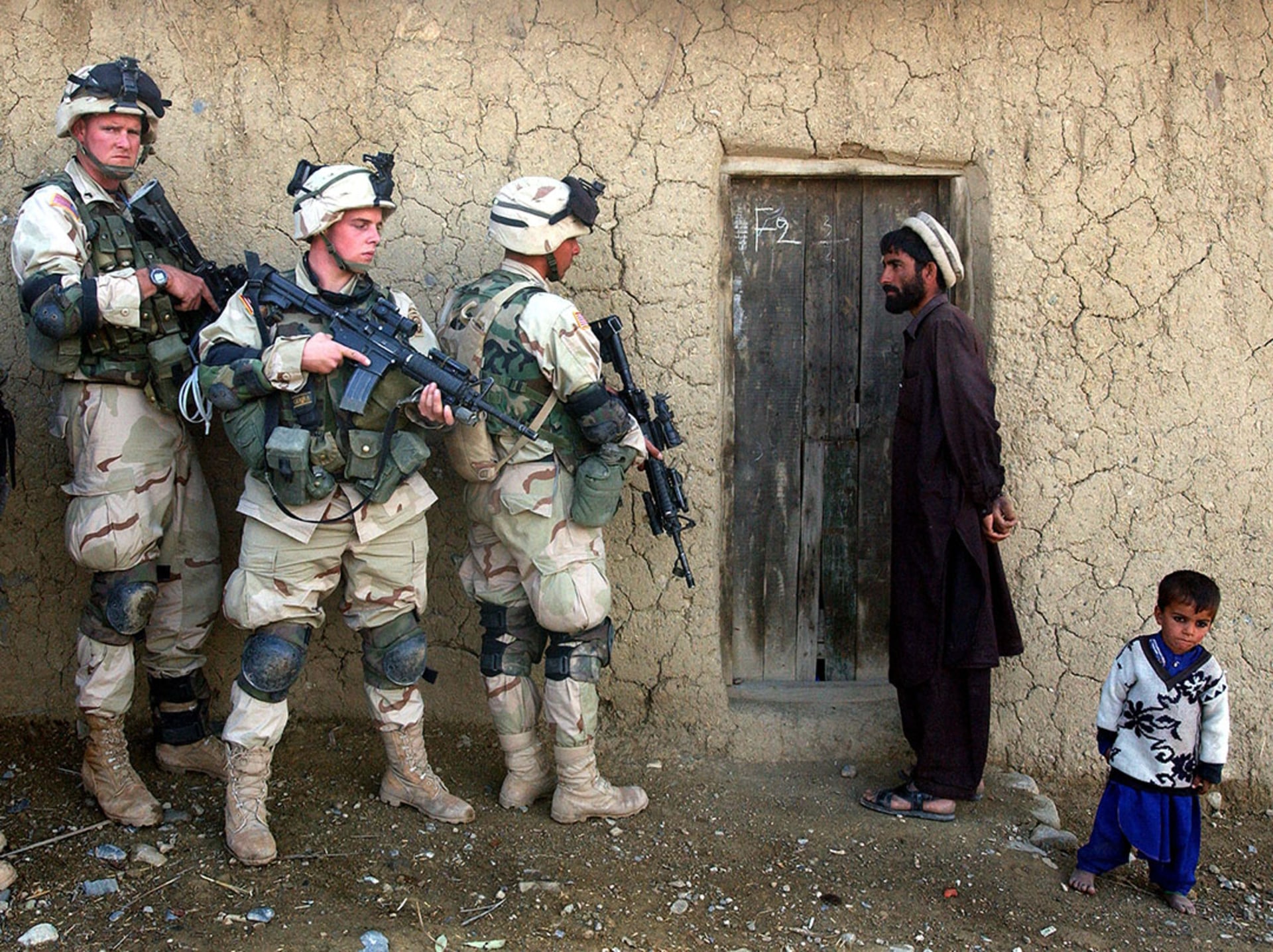 U.S. soldiers prepare to sweep the home of an Afghan man in November 2002. Scott Nelson/Getty Images