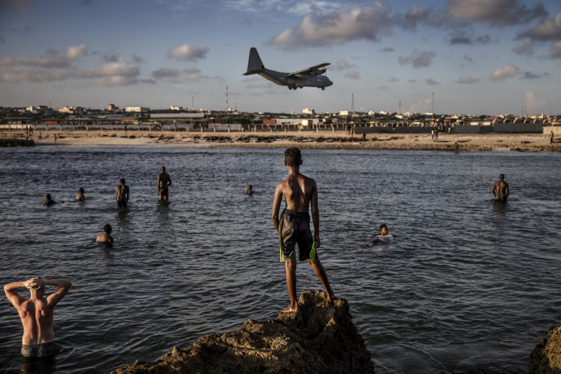 Beachgoers watch a military plane landing at Mogadishu’s airport, where the U.S. embassy was reopened in 2019.