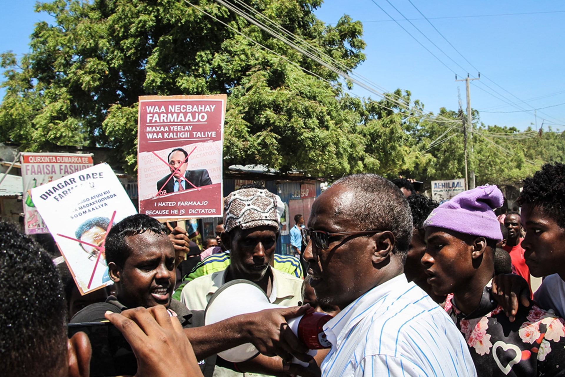 People hold posters during a protest against Farmaajo in Mogadishu on April 25, 2021.