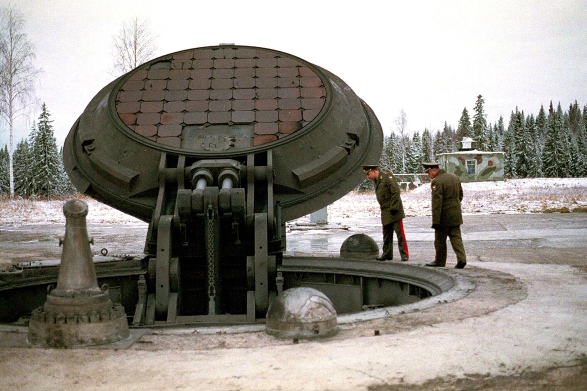Russian military officials peer into an opened silo of an intercontinental ballistic Topol-M missile at an undisclosed location. 
