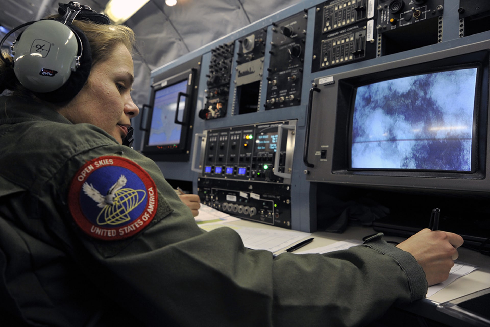 A U.S. Air Force member takes aerial photographs while flying an observation mission. 
