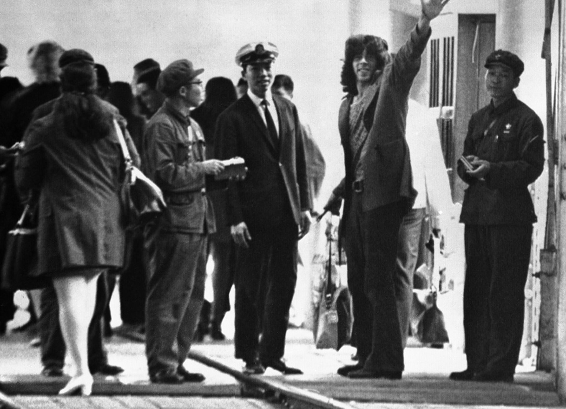 Glenn Cowan, a member of the U.S. ping-pong team, waves to reporters after entering mainland China.
