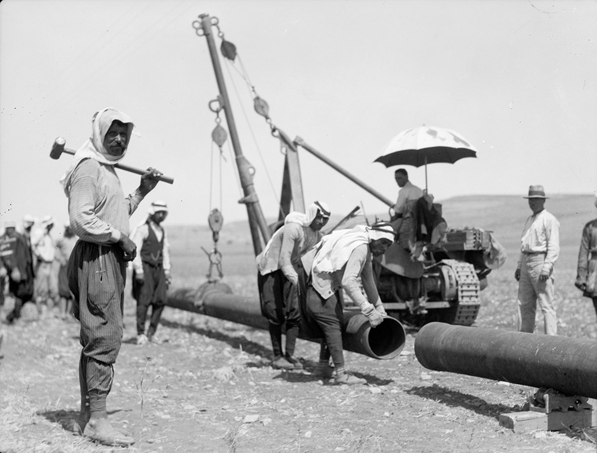 Workers for the Iraq Petroleum Company connect an oil pipeline in July 1933. 
