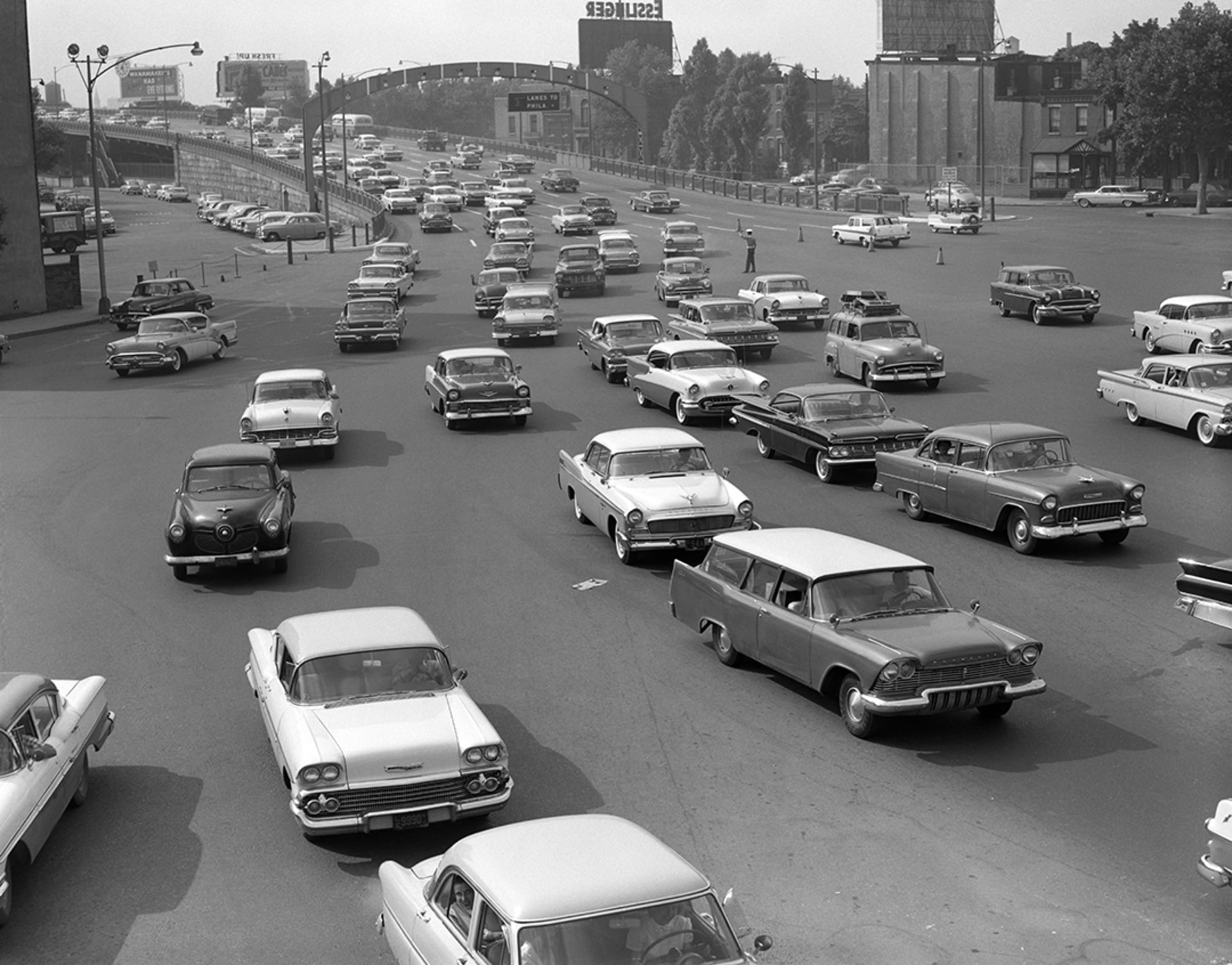 Cars crowd the exit ramp off a highway in the 1950s. H. 
