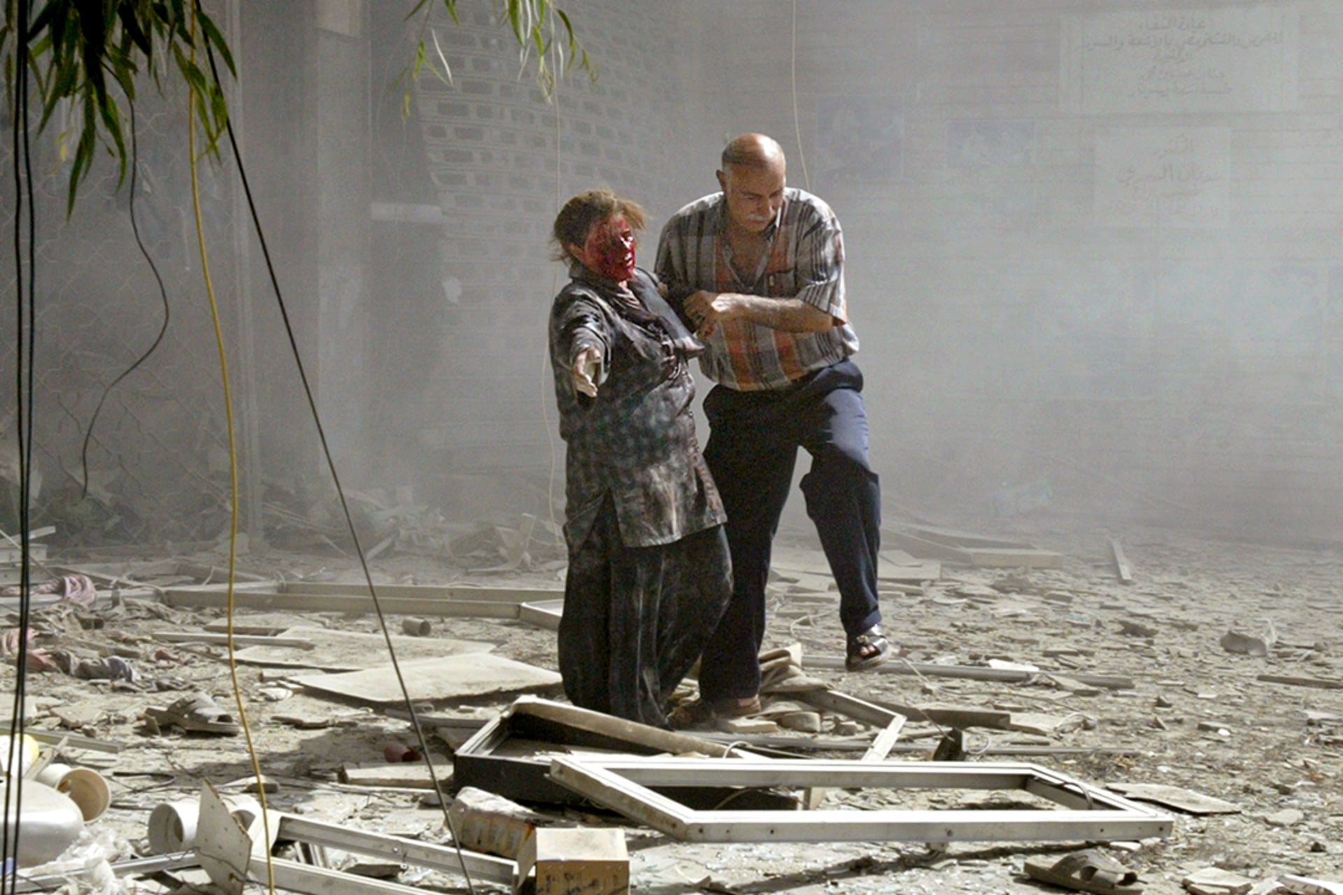 A man helps a wounded woman in the aftermath of bombings in central Baghdad.