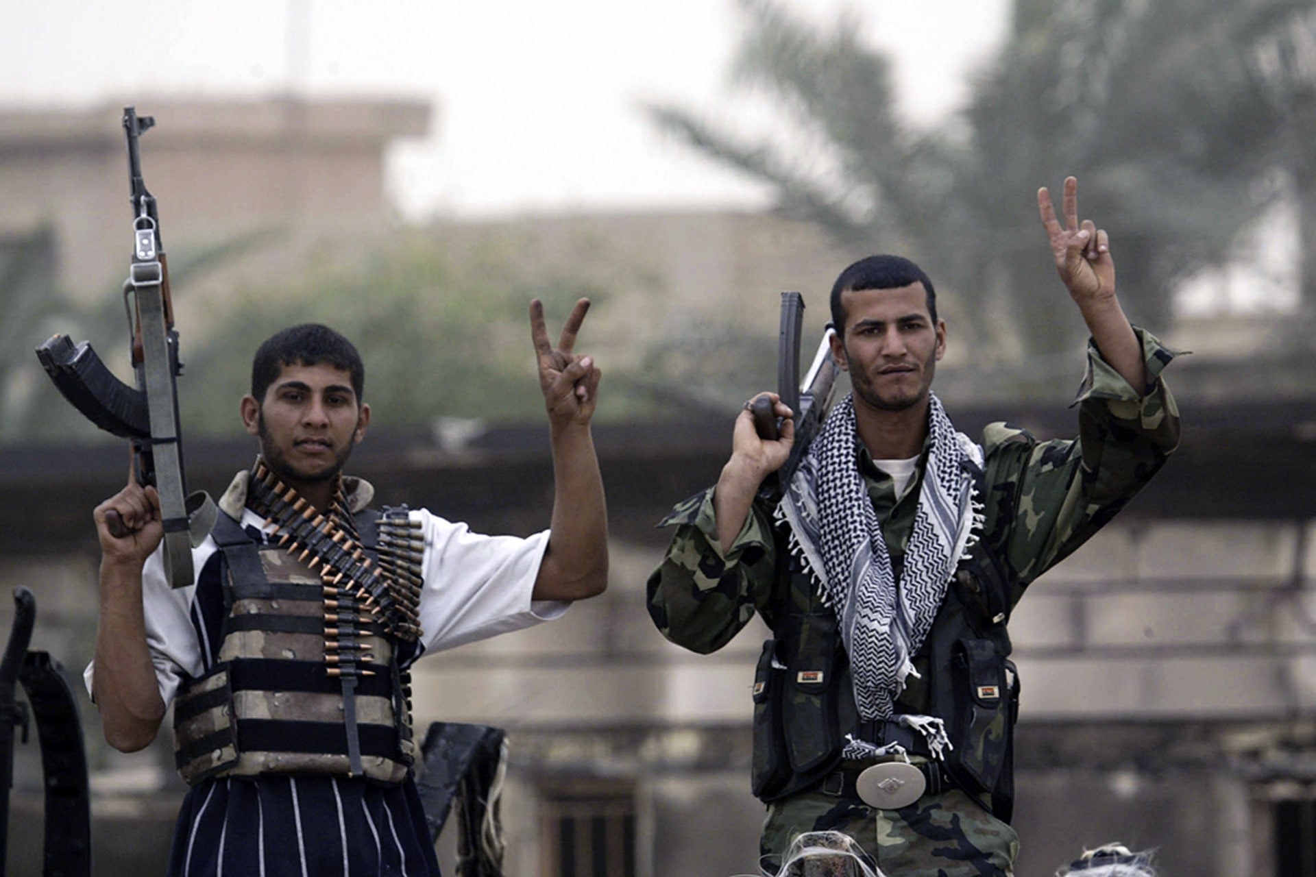 In Basra, fighters loyal to cleric Muqtada al-Sadr flash the victory sign in Basra.