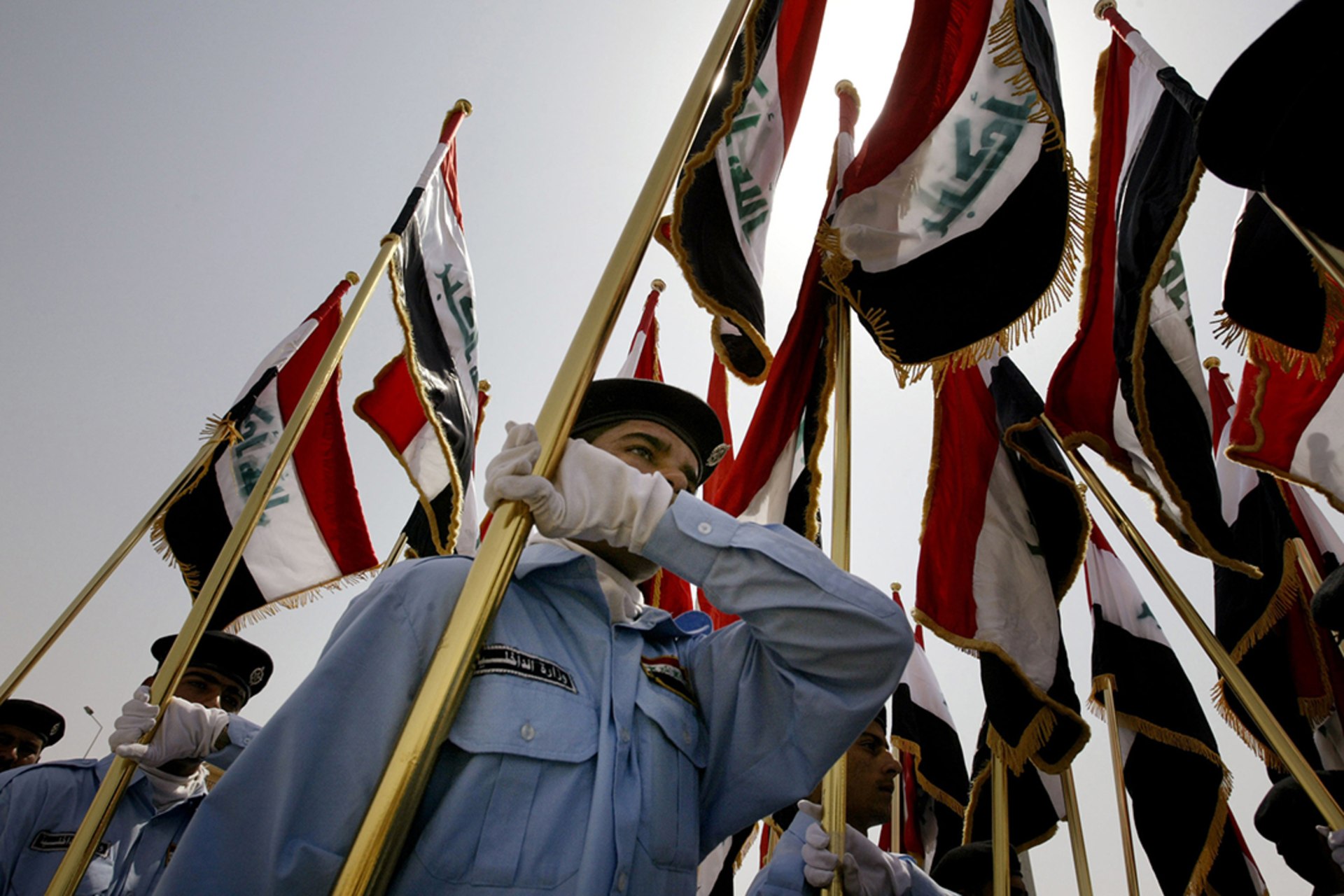 Security forces parade with Iraqi flags during a handover ceremony at the government headquarters in Ramadi.