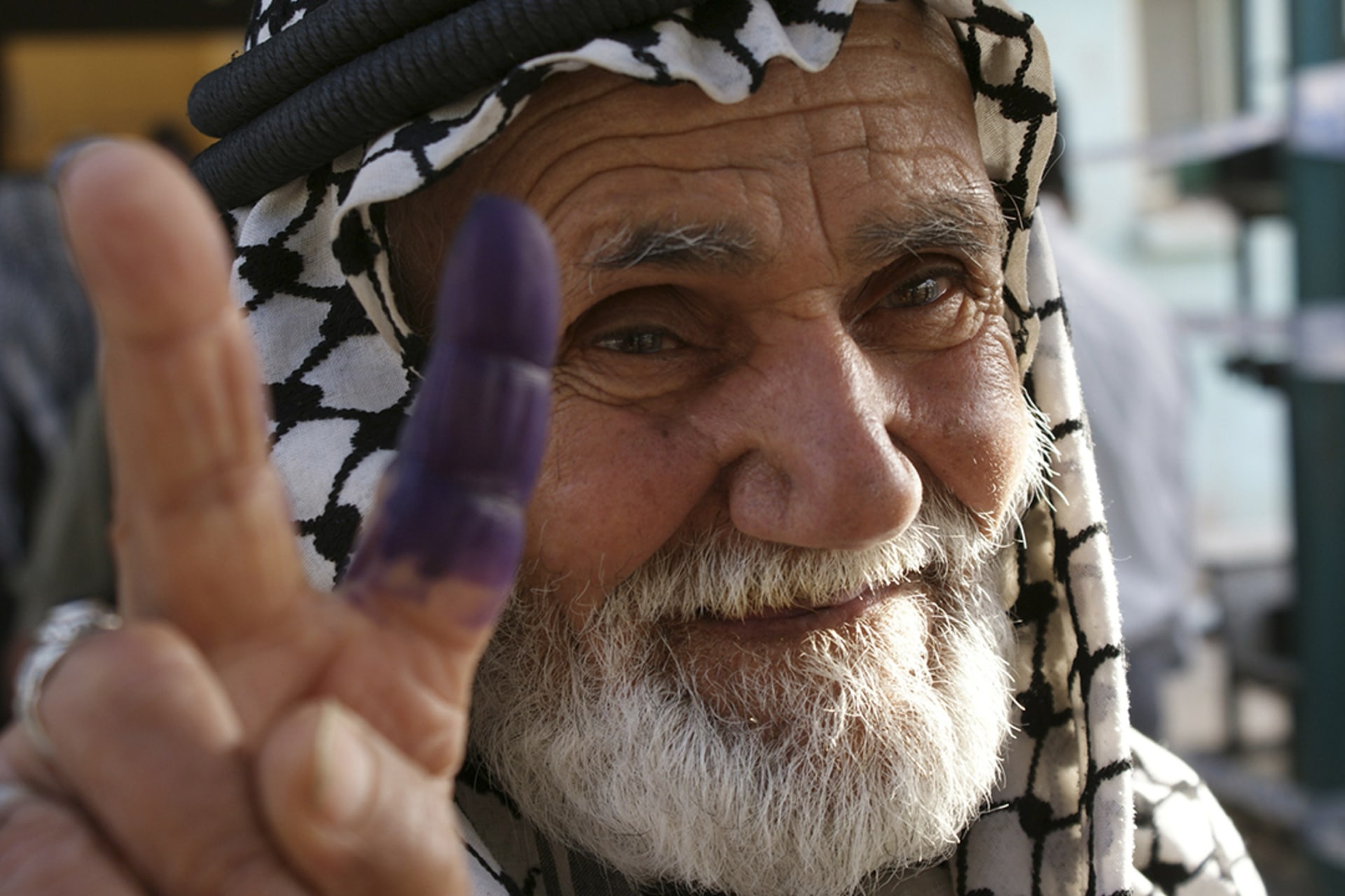 An elderly man flashes the victory sign after voting in Sadr City, a district of Baghdad.