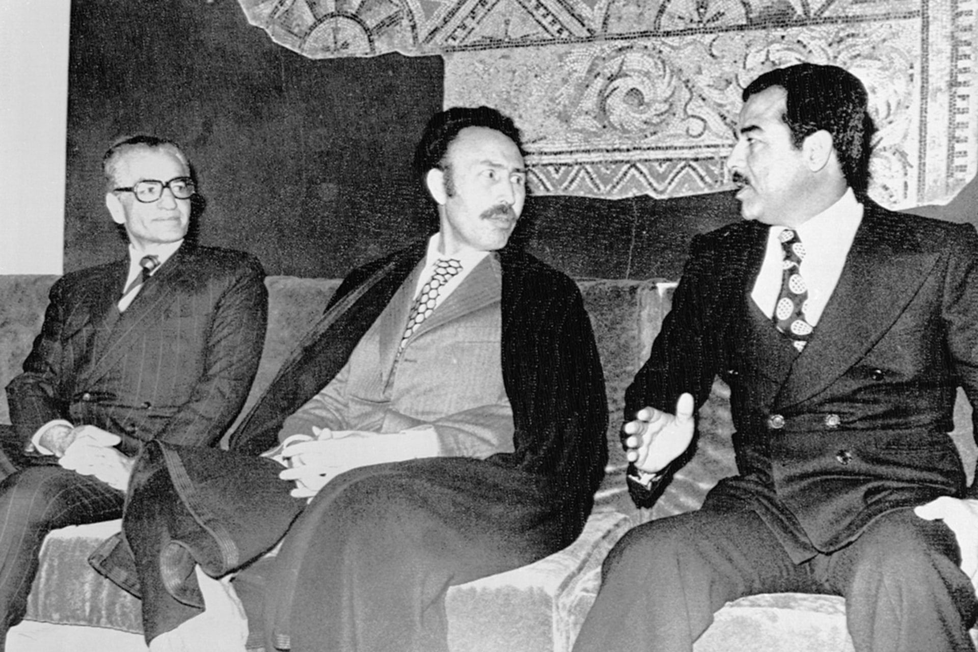 Iranian Shah Mohammad Reza Pahlavi, Algerian President Houari Boumediene, and Vice Chairman of the Iraqi Revolutionary Command Council Saddam Hussein talk on March 3, 1975, in Algiers, Algeria.