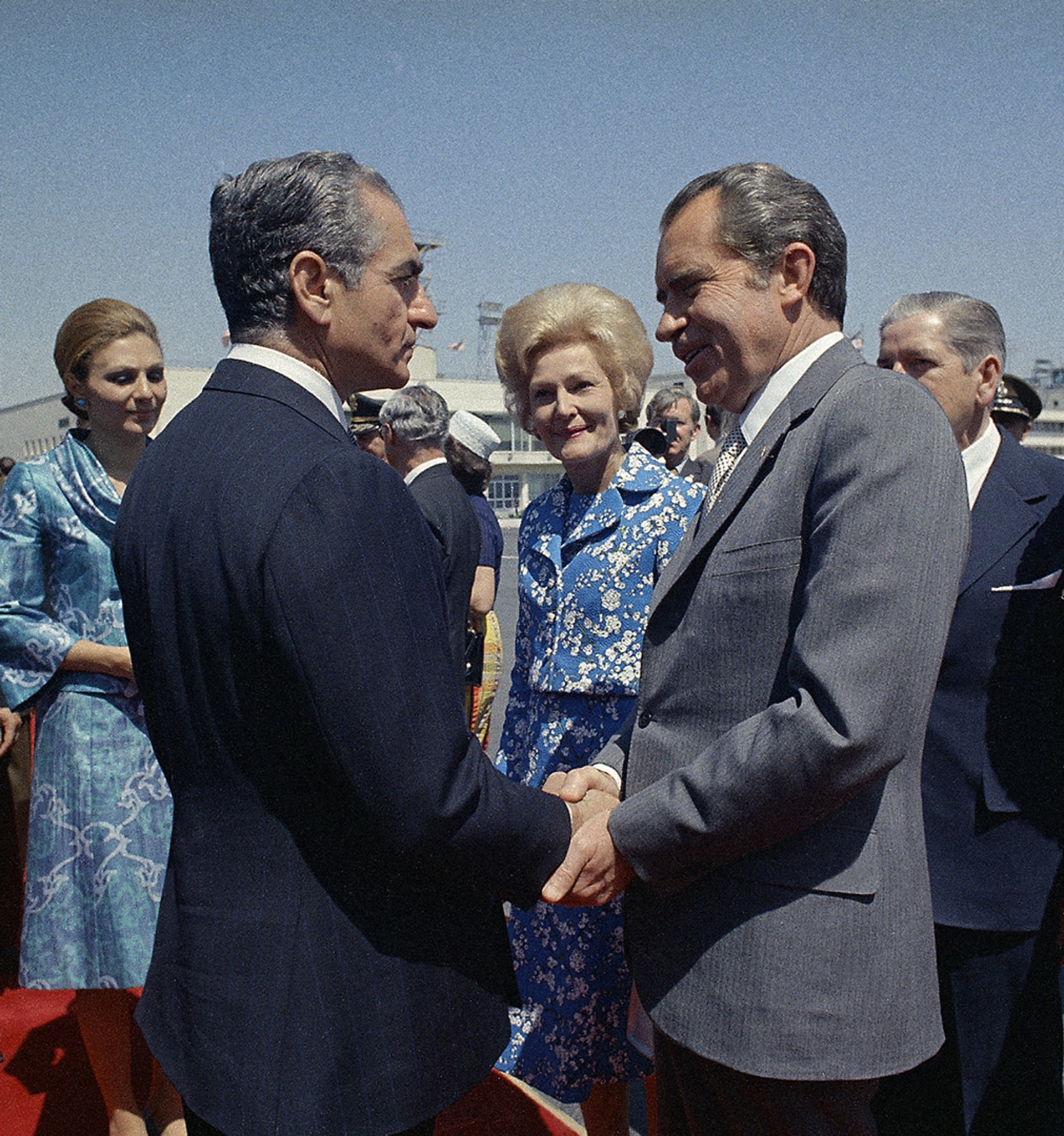 U.S. President Richard Nixon clasps the shah’s hand as he and First Lady Patricia Nixon prepare to depart from Iran.