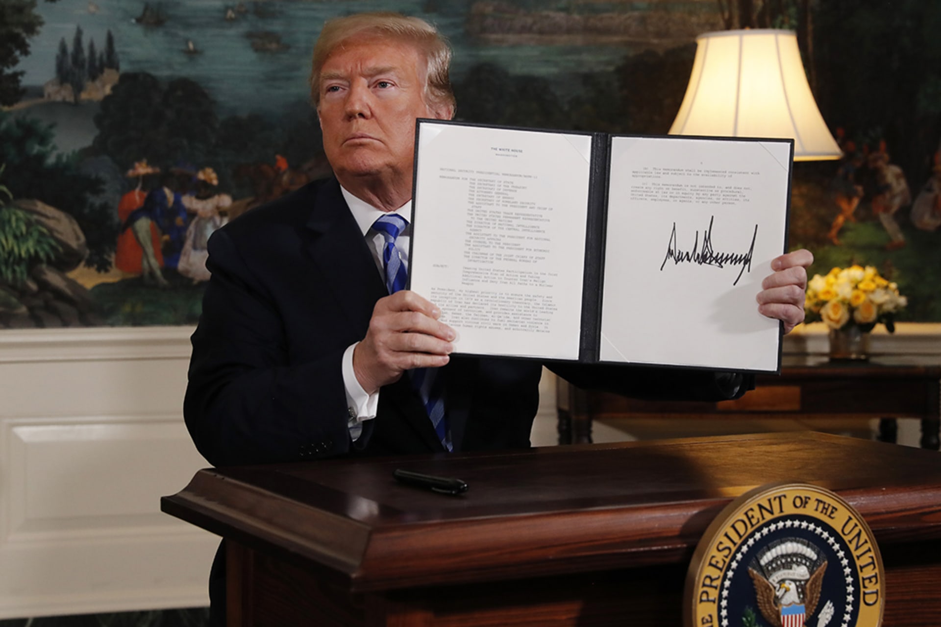 U.S. President Donald J. Trump displays a presidential memorandum after announcing his intent to withdraw from the Iran nuclear agreement.