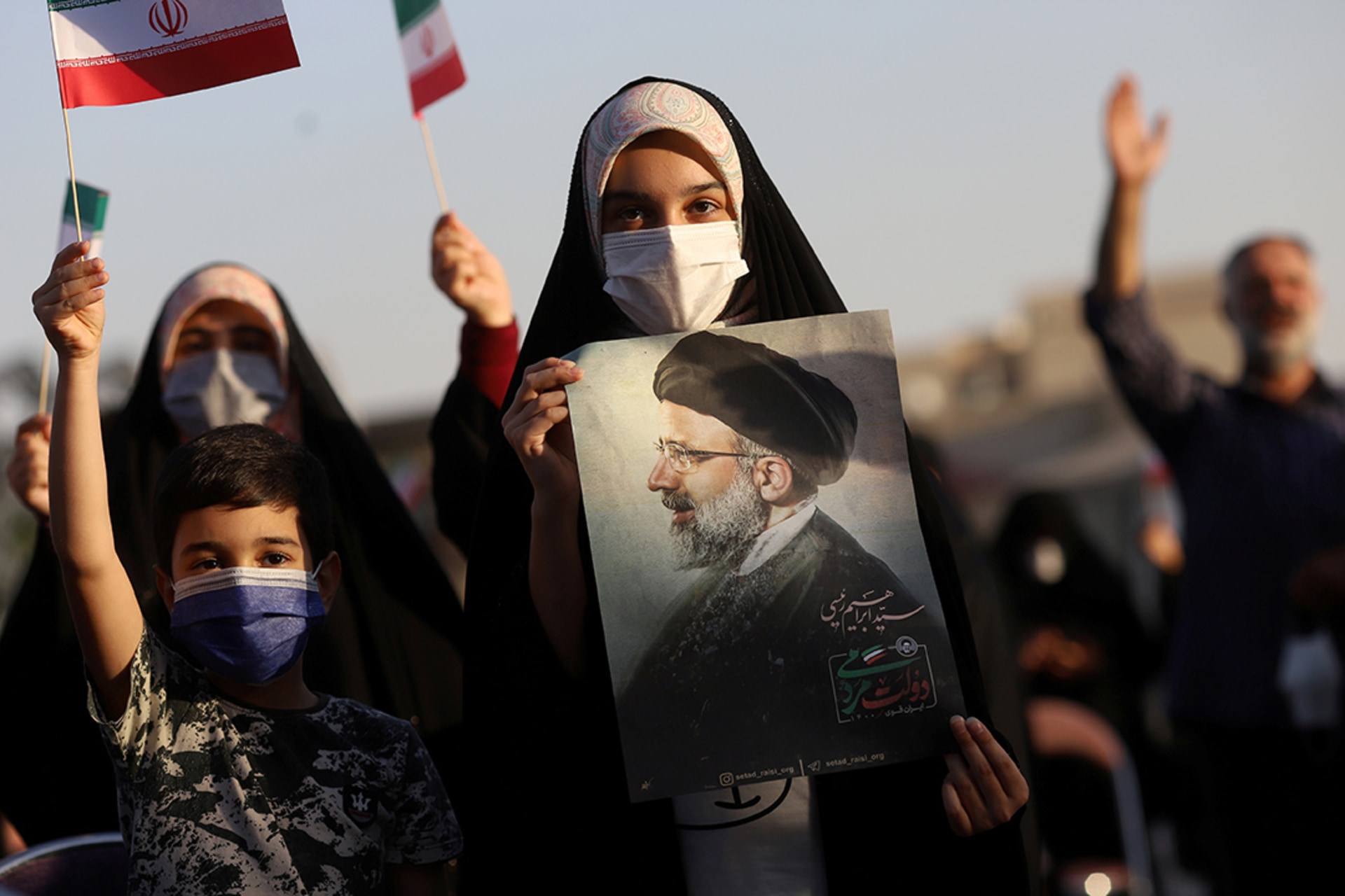 A supporter of Ebrahim Raisi displays his portrait during a rally celebrating his presidential election victory.