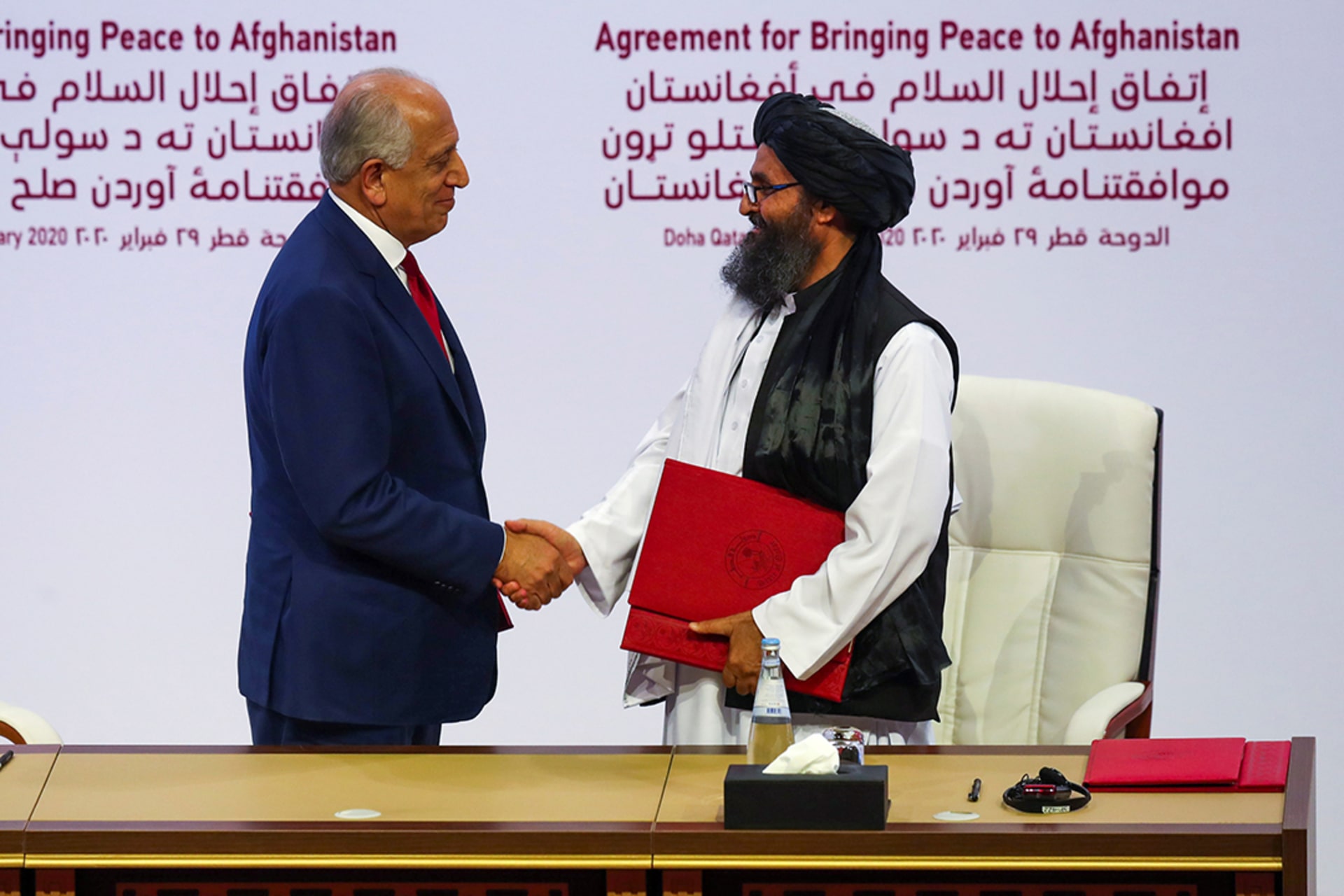 Mullah Abdul Ghani Baradar, the leader of the Taliban delegation, and Zalmay Khalilzad, U.S. envoy for peace in Afghanistan, shake hands after signing an agreement in Doha, Qatar. Ibraheem al Omari/Reuters