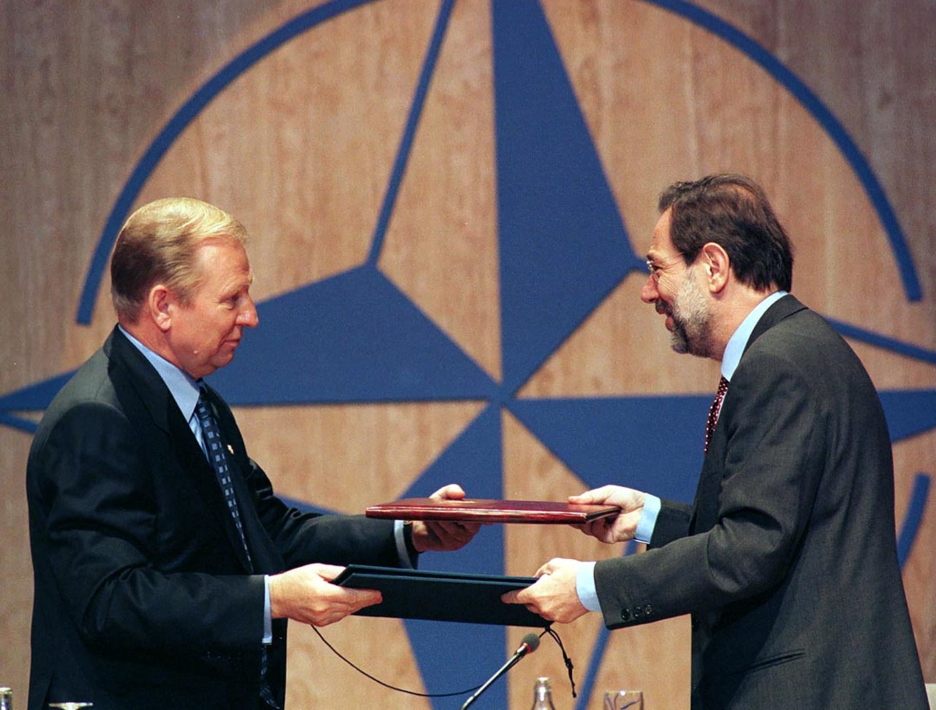 Ukrainian President Leonid Kuchma exchanges documents with NATO Secretary-General Javier Solana after a signing ceremony during the NATO summit.
