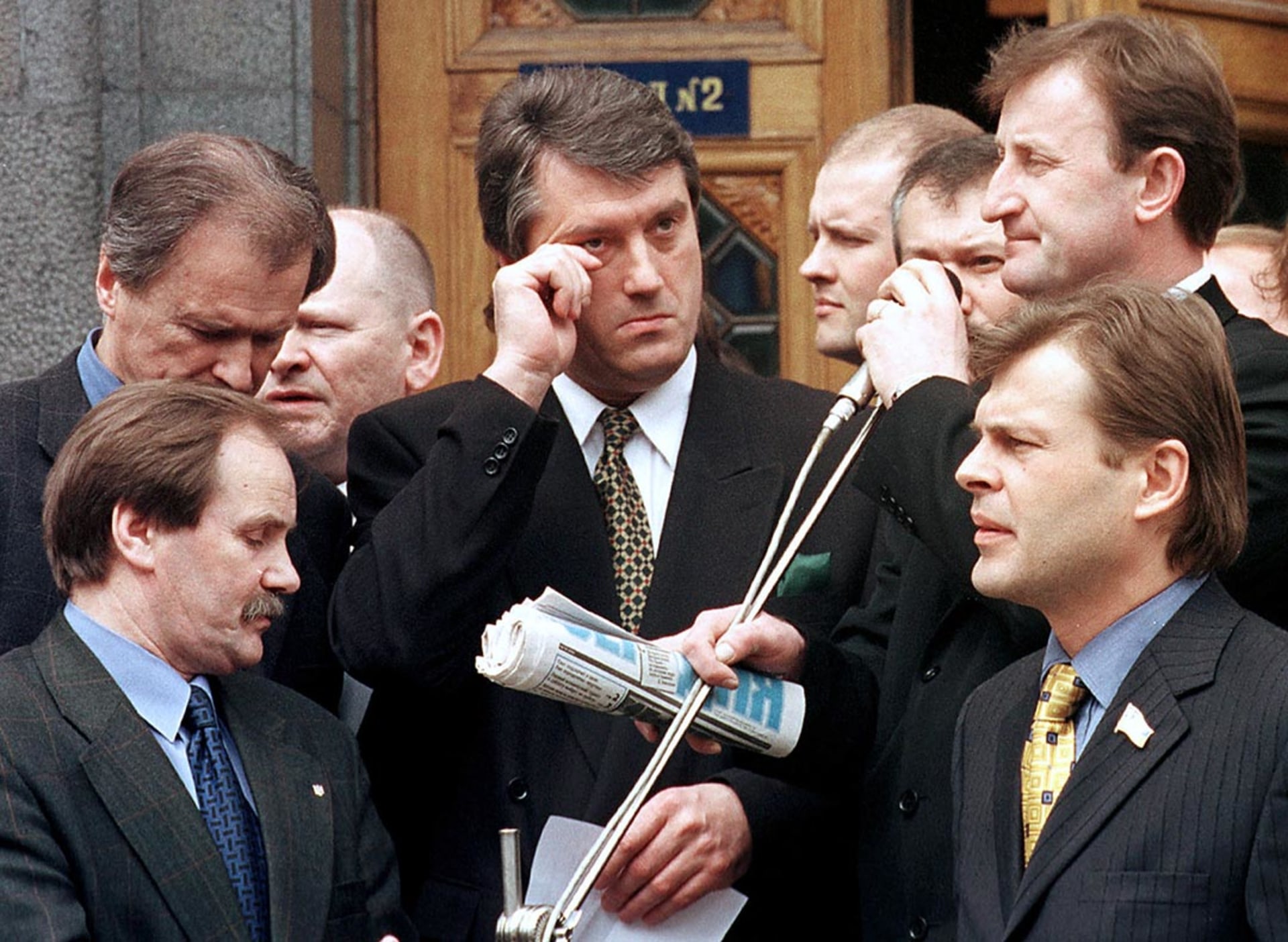 Outgoing Prime Minister Viktor Yushchenko, surrounded by deputies, prepares to address a crowd of supporters. 

