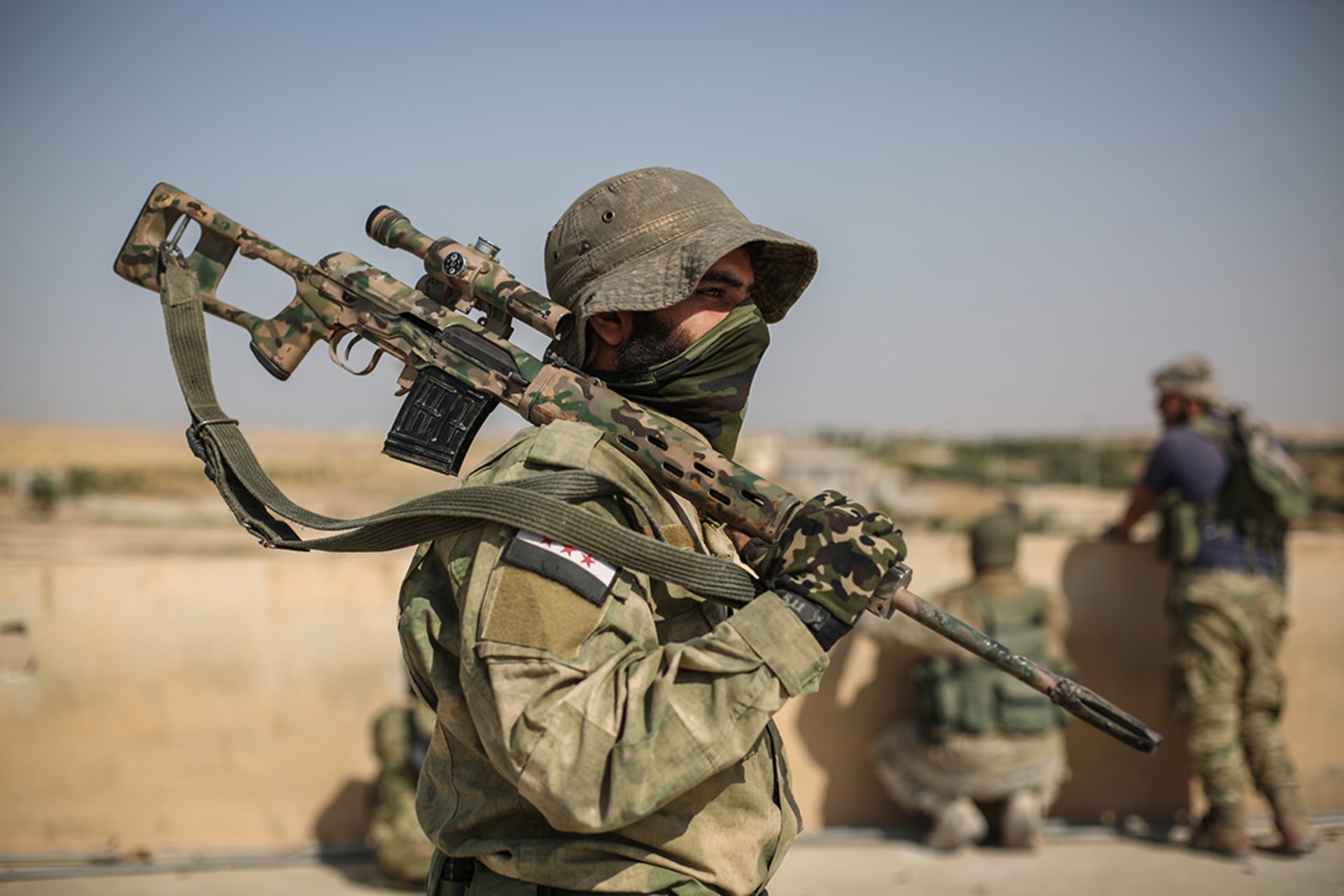 A sniper from the Turkey-backed Free Syrian Army stands on a rooftop in the countryside of Tell Abyad after clashes with Kurdish fighters.