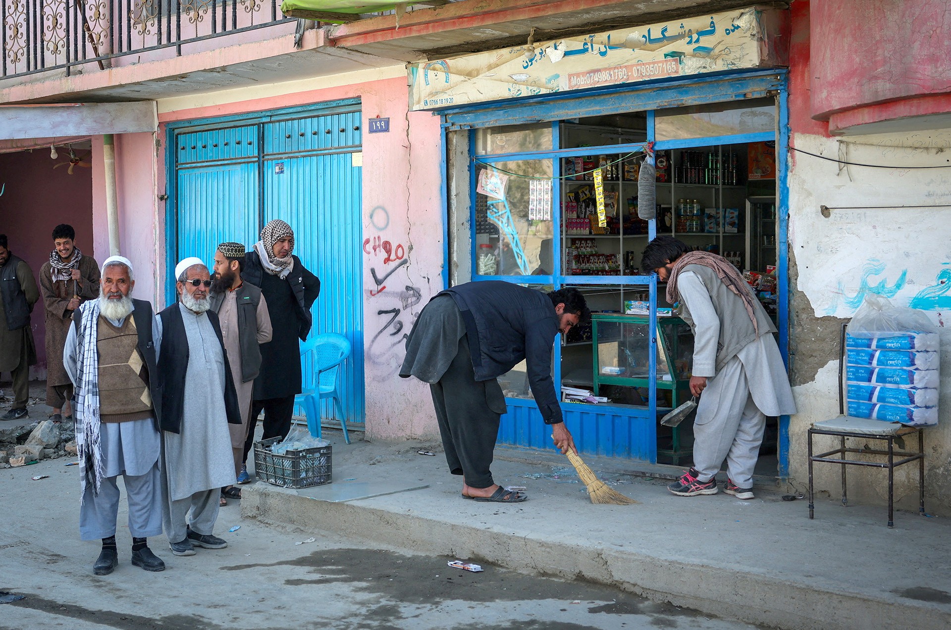 People remove shattered glass from their shop, following Pakistani airstrike, in the Darul Aman locality, in Kabul, Afghanistan, February 27, 2026.