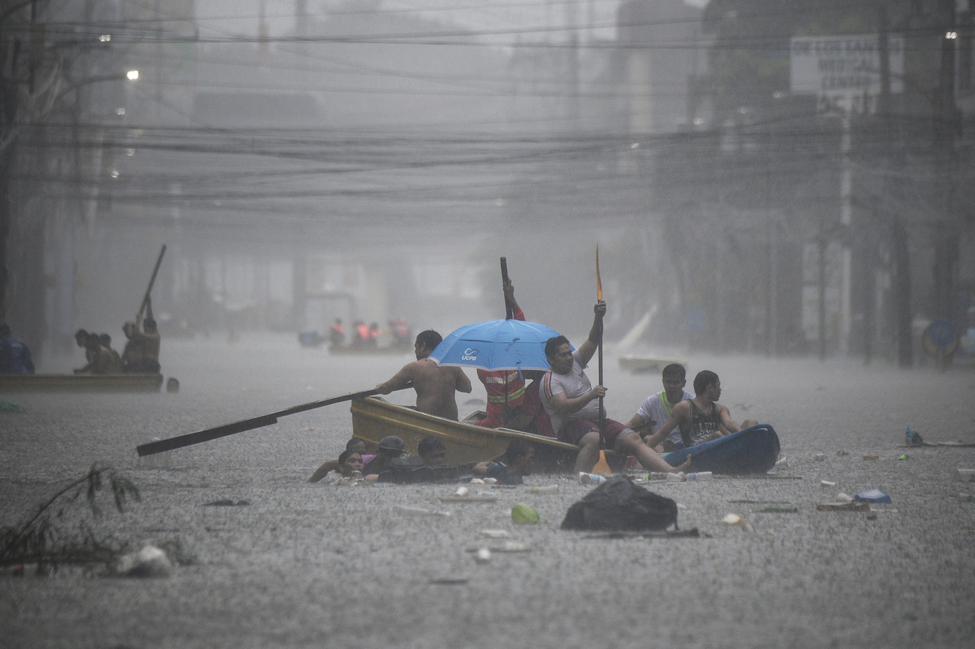 Rescuers paddle their boats along a flooded street in Manila.