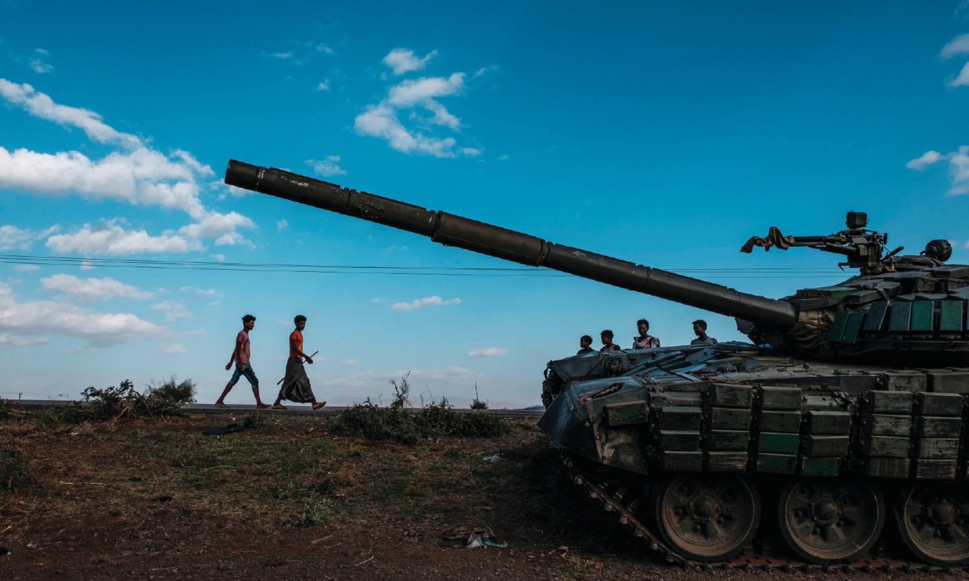 Youngsters walk next to an abandoned tank belonging to Tigrayan forces south of the town of Mehoni, Ethiopia, on December 11, 2020. 