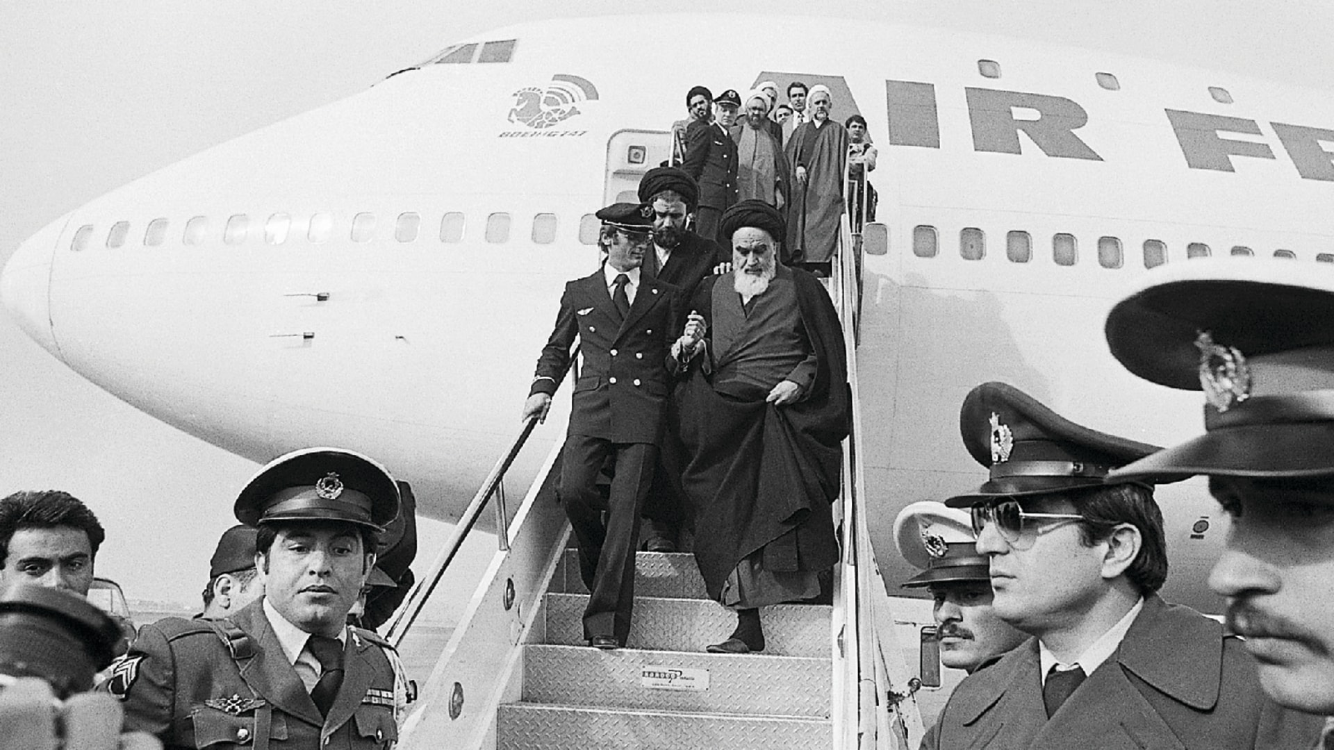 Ayatollah Ruhollah Khomeini descends the steps of an airplane as he arrives in Tehran, Iran.
