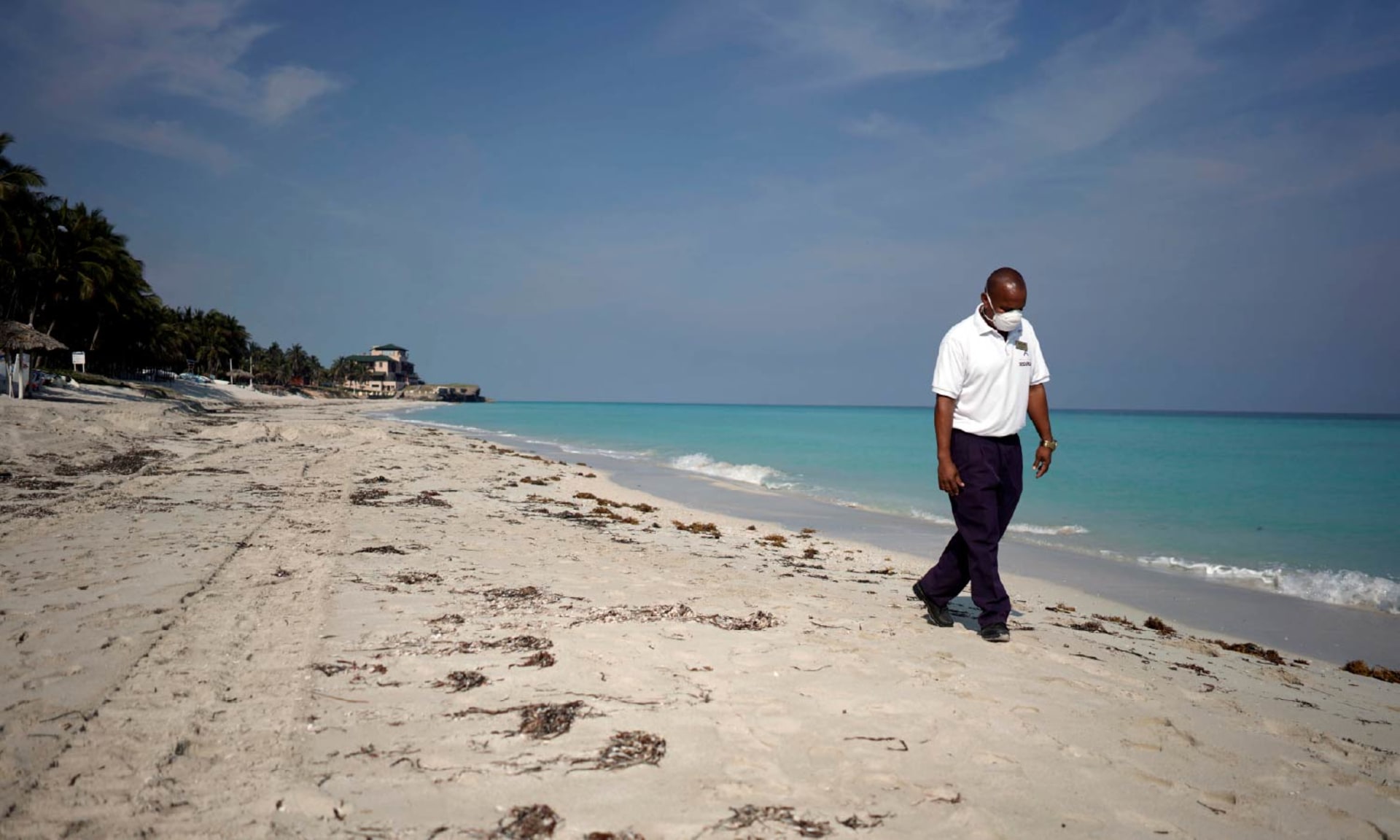A security agent wearing a protective mask walks on the beach amid concerns about the spread of the coronavirus disease (COVID-19), in Varadero, Cuba.