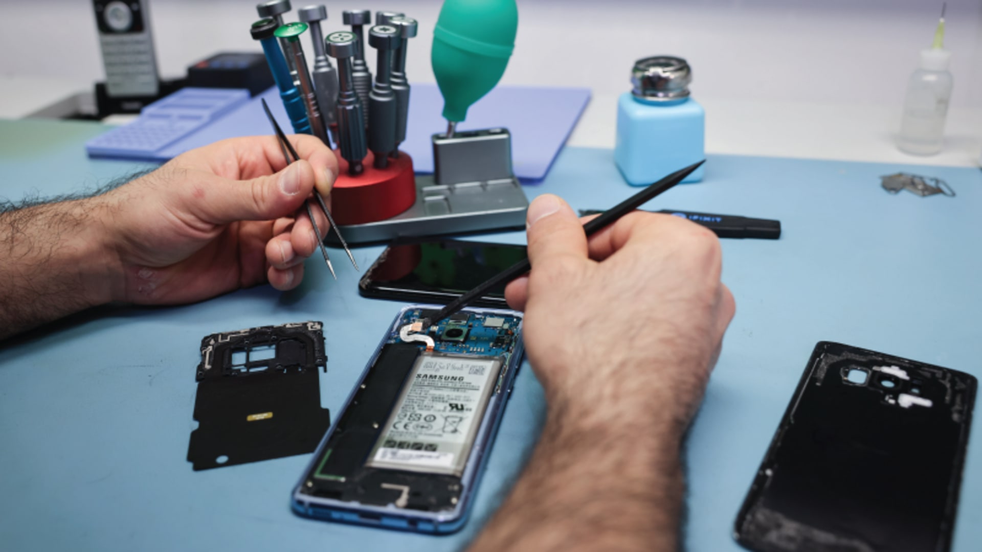 A technician works on a smartphone with a defective display in his small specialist store for repairs and accessories in Hamburg, Germany on April 23, 2024.