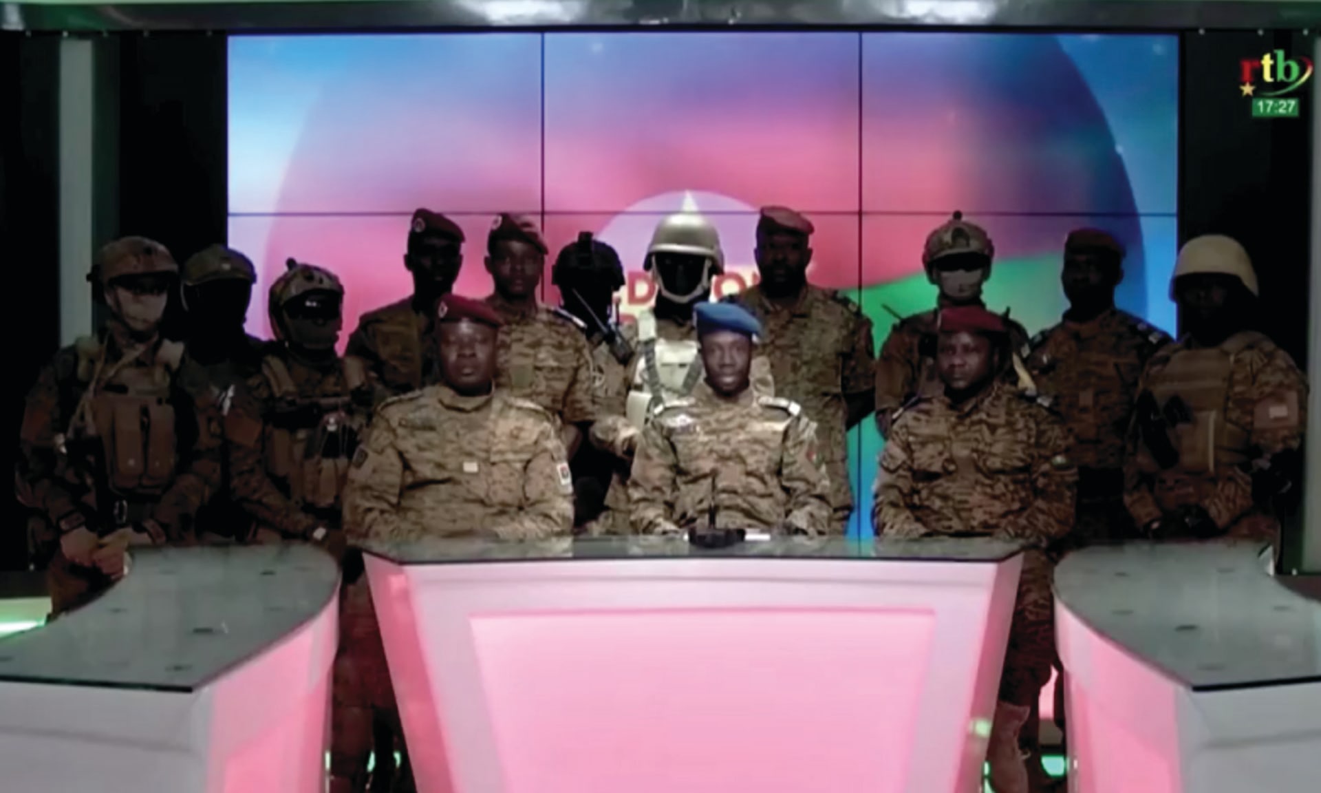 A group of army officials sits at a desk for a broadcast. A spokesperson for the Patriotic Movement for Safeguarding and Restoration, announces the army has taken control of Burkina Faso.