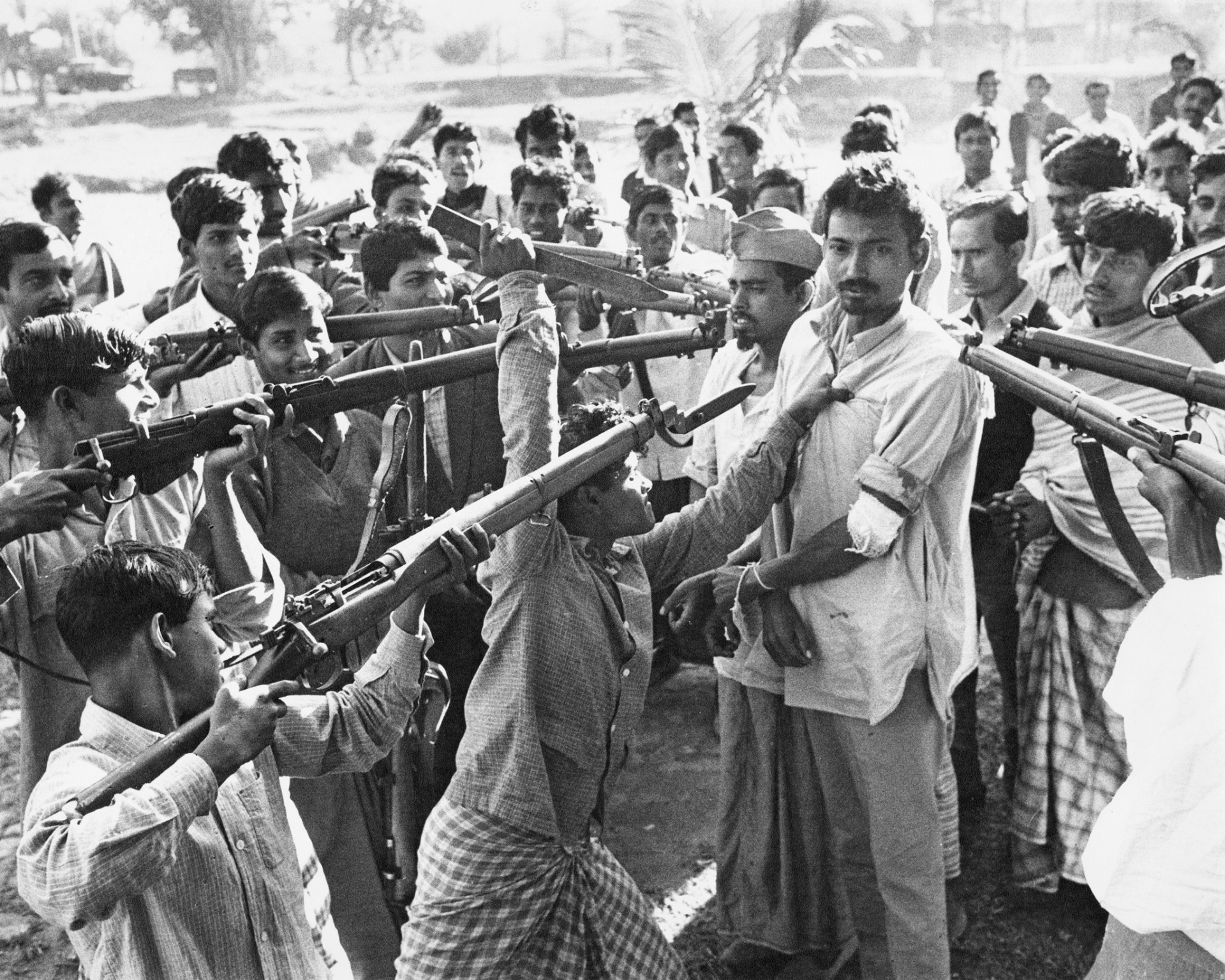 Bangladeshi Freedom Fighters holding weapons surround men accused of working with the government in East Pakistan, now Bangladesh.