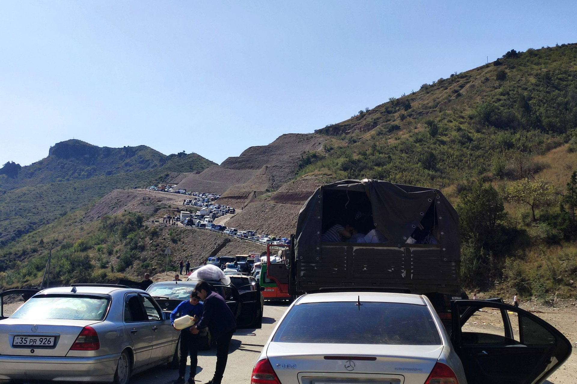 Fleeing Armenians sit in a long traffic jam of vehicles along the Lachin corridor, a mountainous road.