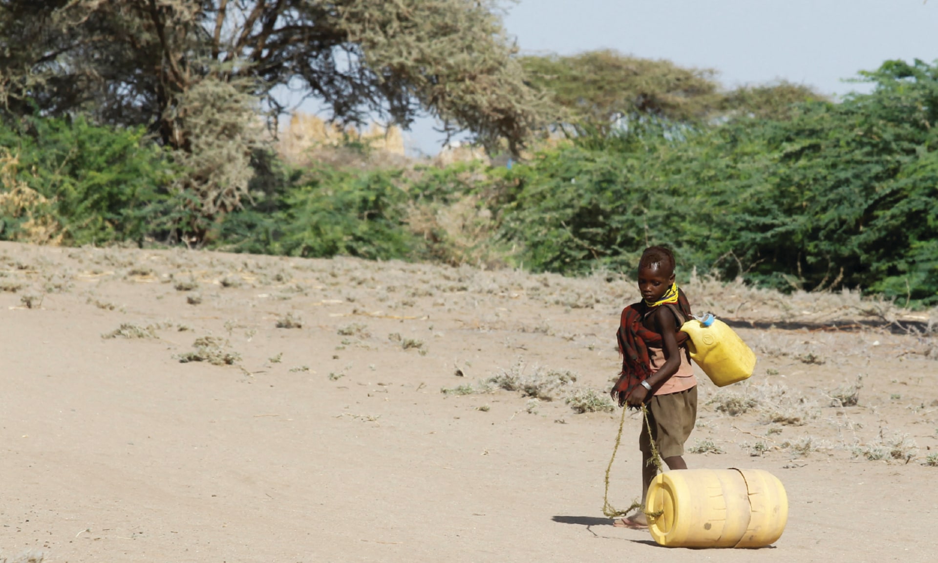 A young girl, affected by drought due to failed rain seasons, pulls an empty can in Kanmukuny, Kenya on October 11, 2022.