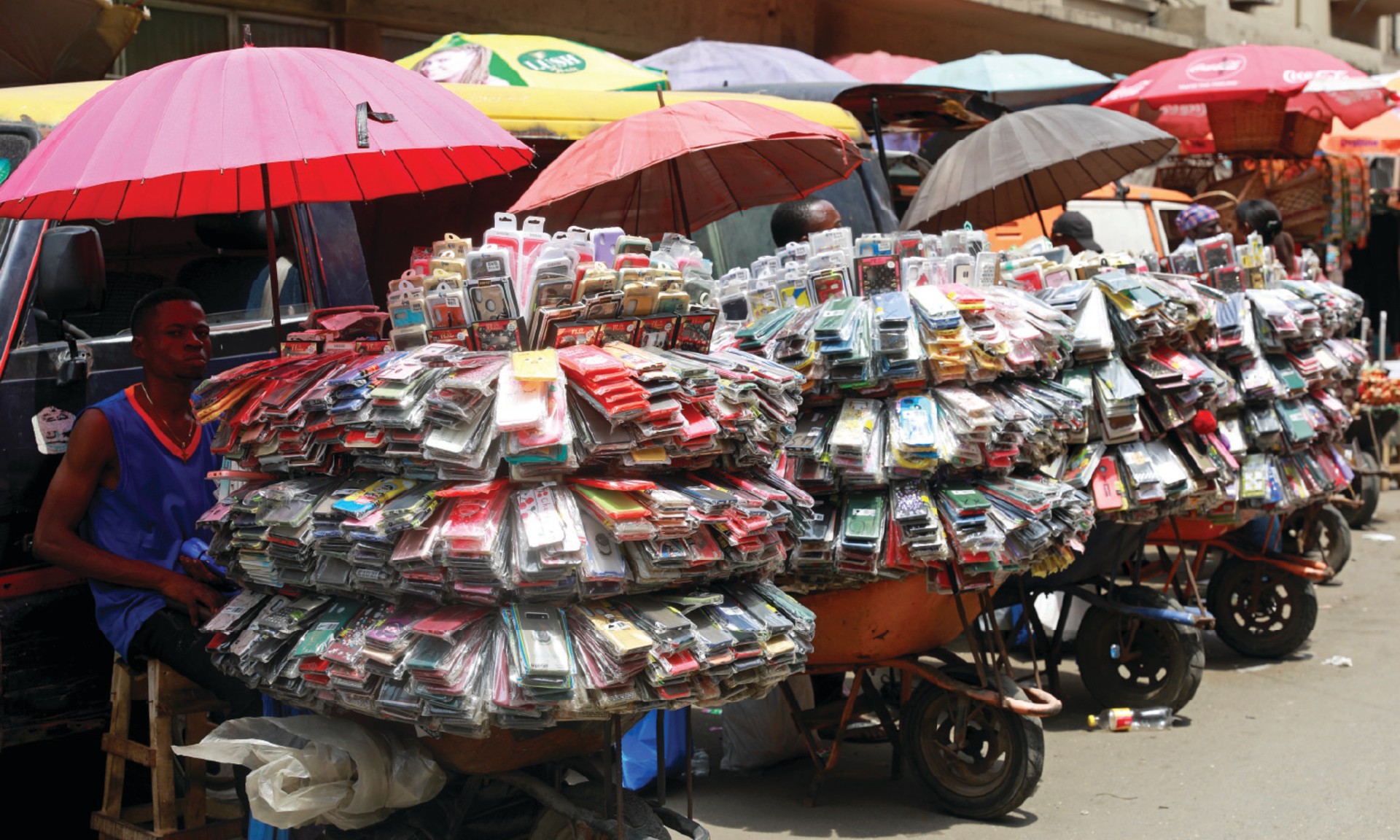 A phone accessory vendor sits beside his goods, hundreds of phone cases, in Lagos, Nigeria.
