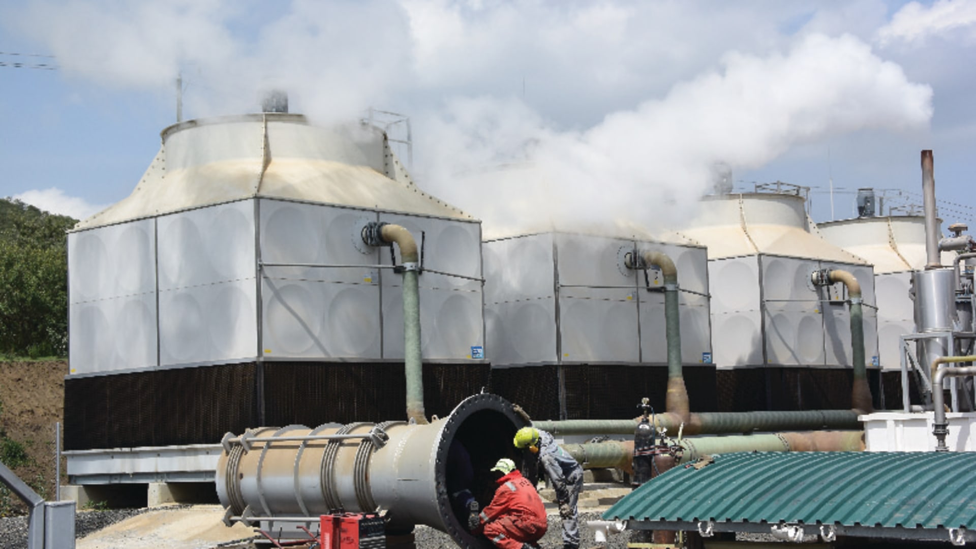 Engineers crouch in front of the Olkaria geothermal plant, which supplies clean, renewable energy, was partly funded by international development banks in Nairobi, Kenya.