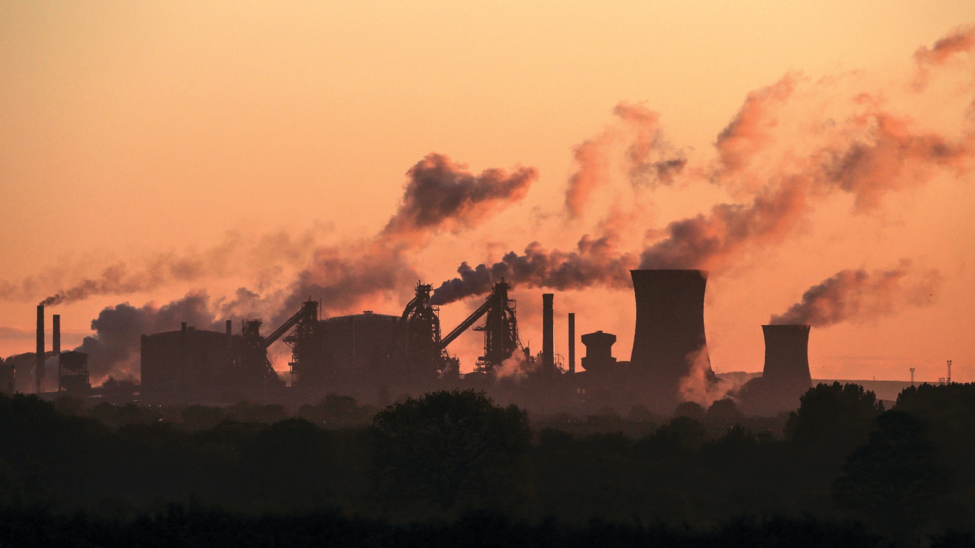Smokestacks emitting smoke at a steel plant pictured at dawn in Lincolnshire, England.